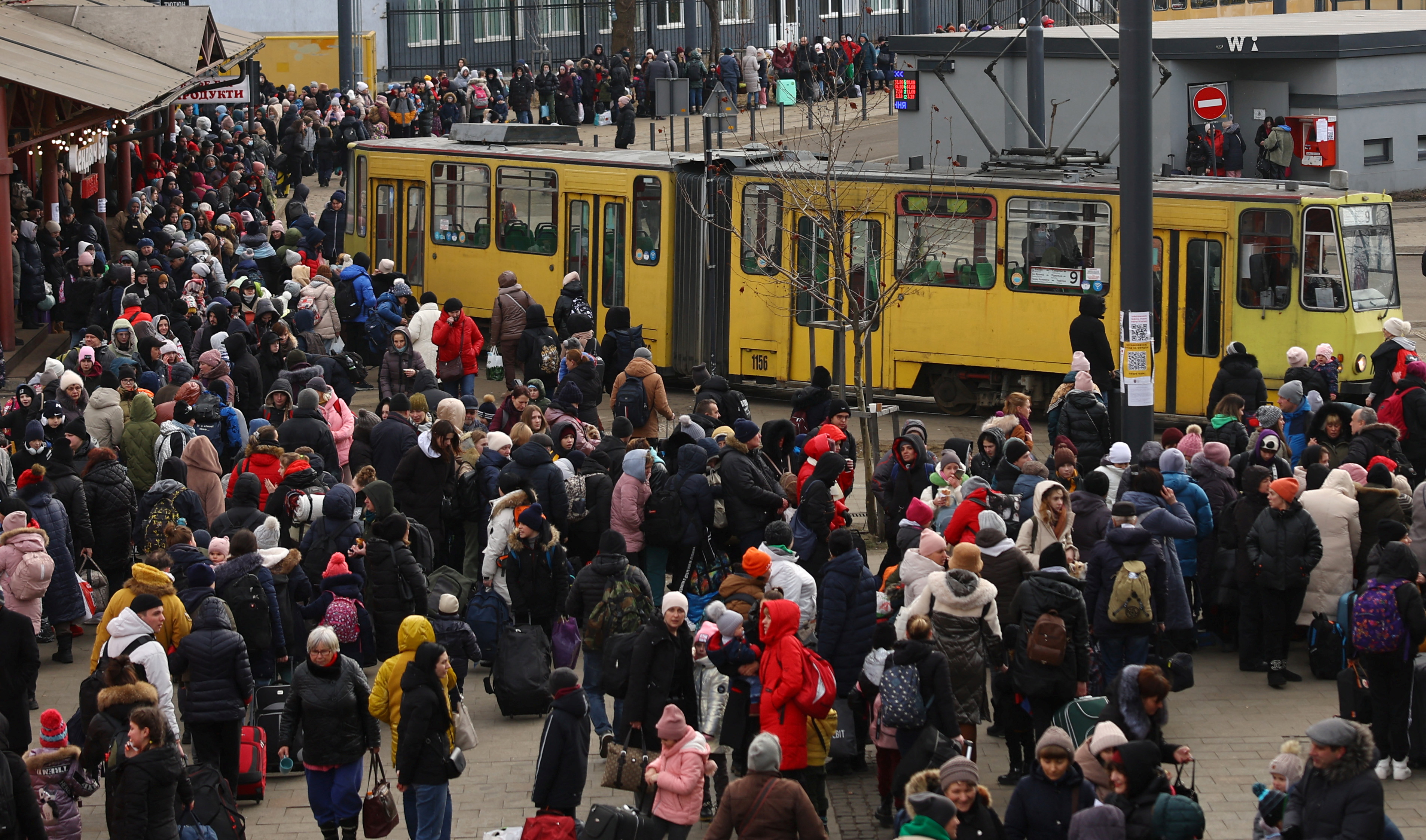 Refugees wait for their transfer to Poland at the train station in Lviv