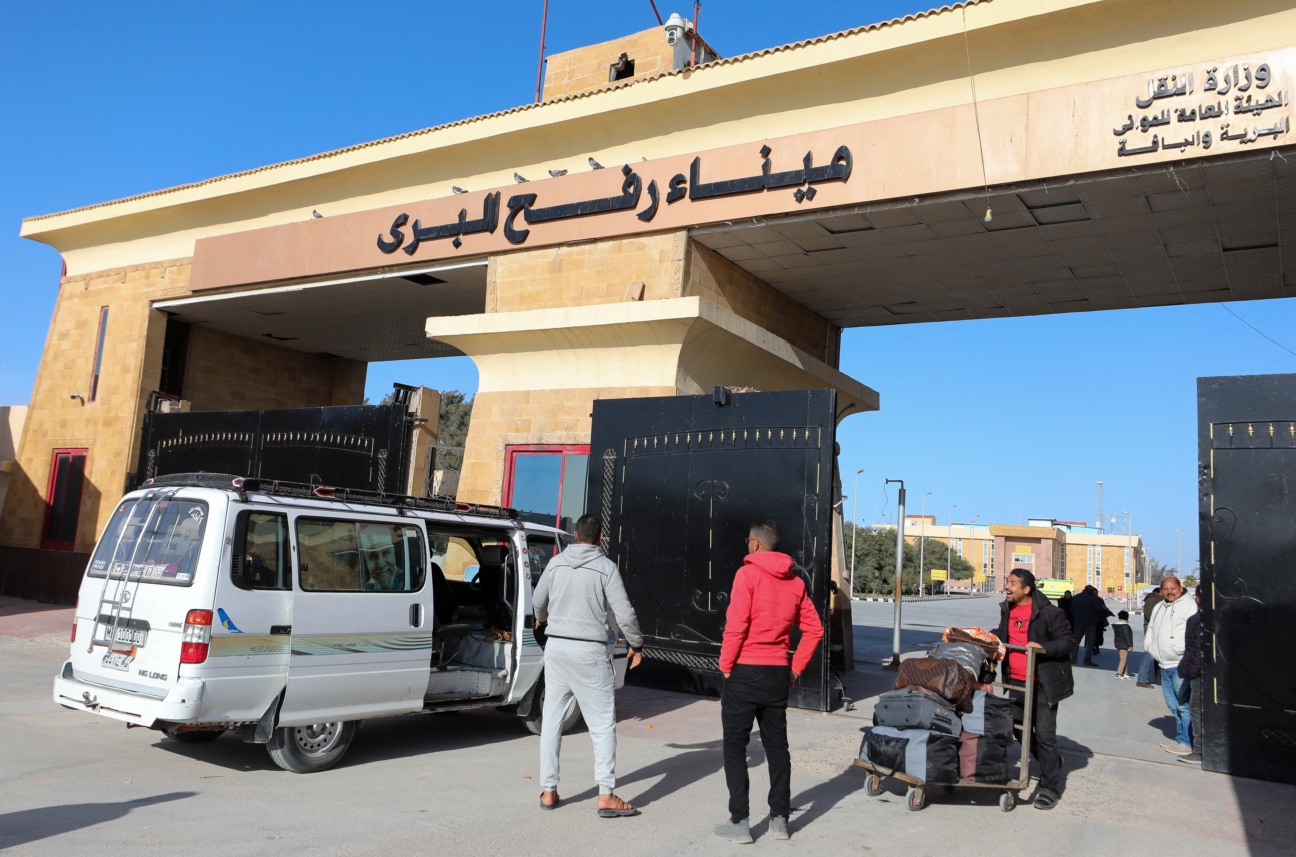 A man pushes a trolley with luggage as he crosses from Gaza to Egypt, at the Rafah border crossing