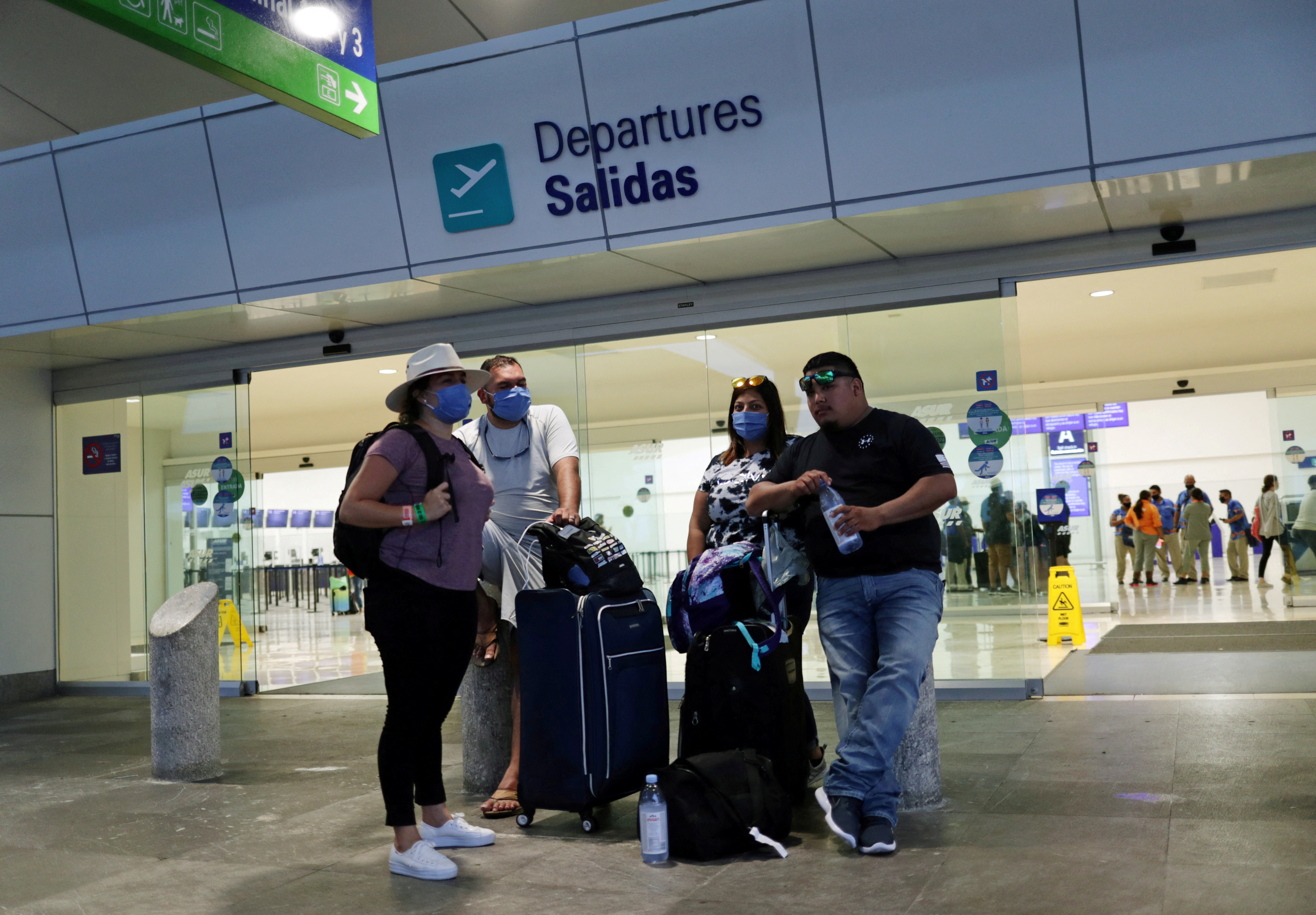 Tourists wait to depart from Cancun's international airport