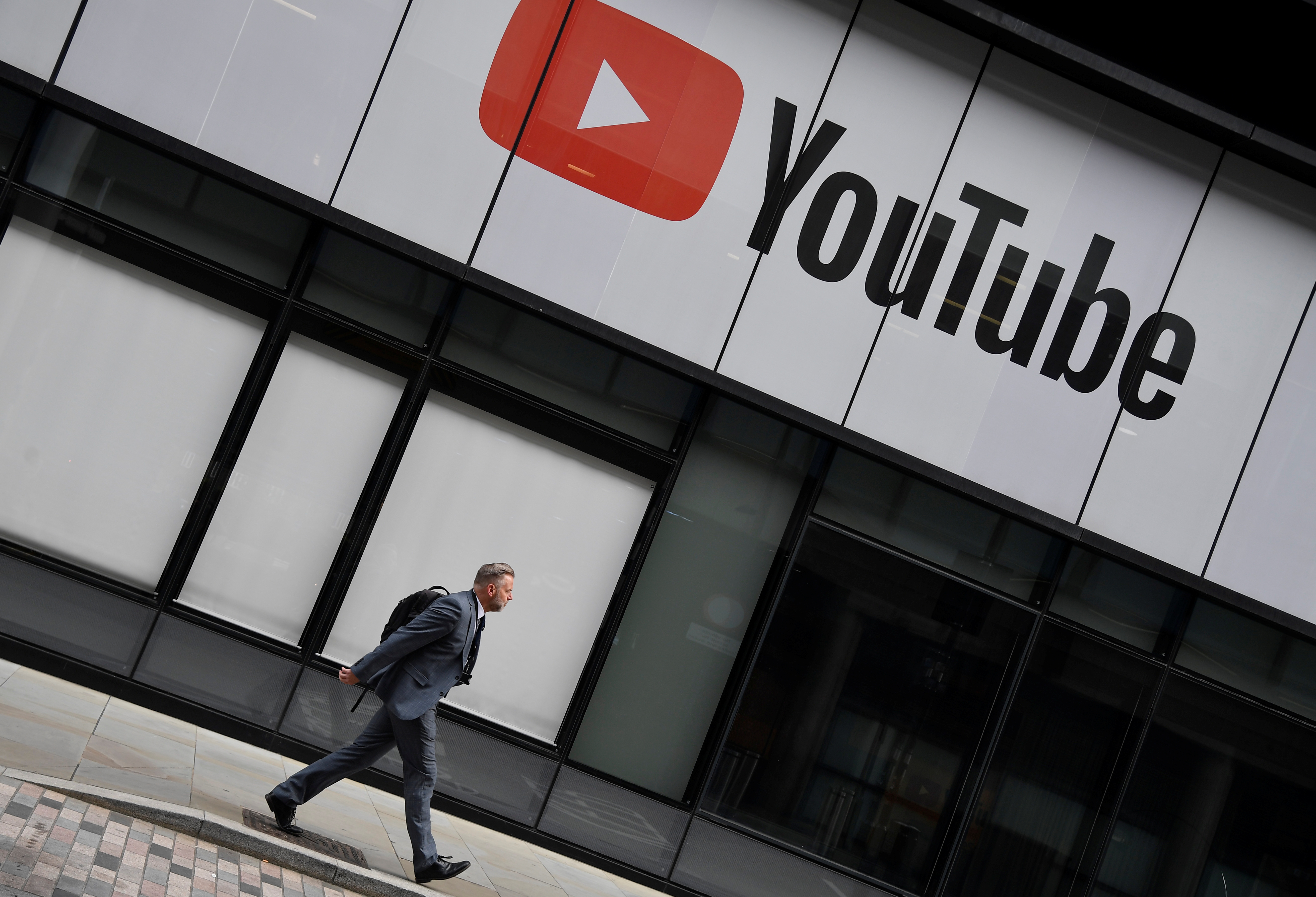 A worker walks past YouTube offices, in King's Cross, London, Britain, September 11, 2020. REUTERS/Toby Melville