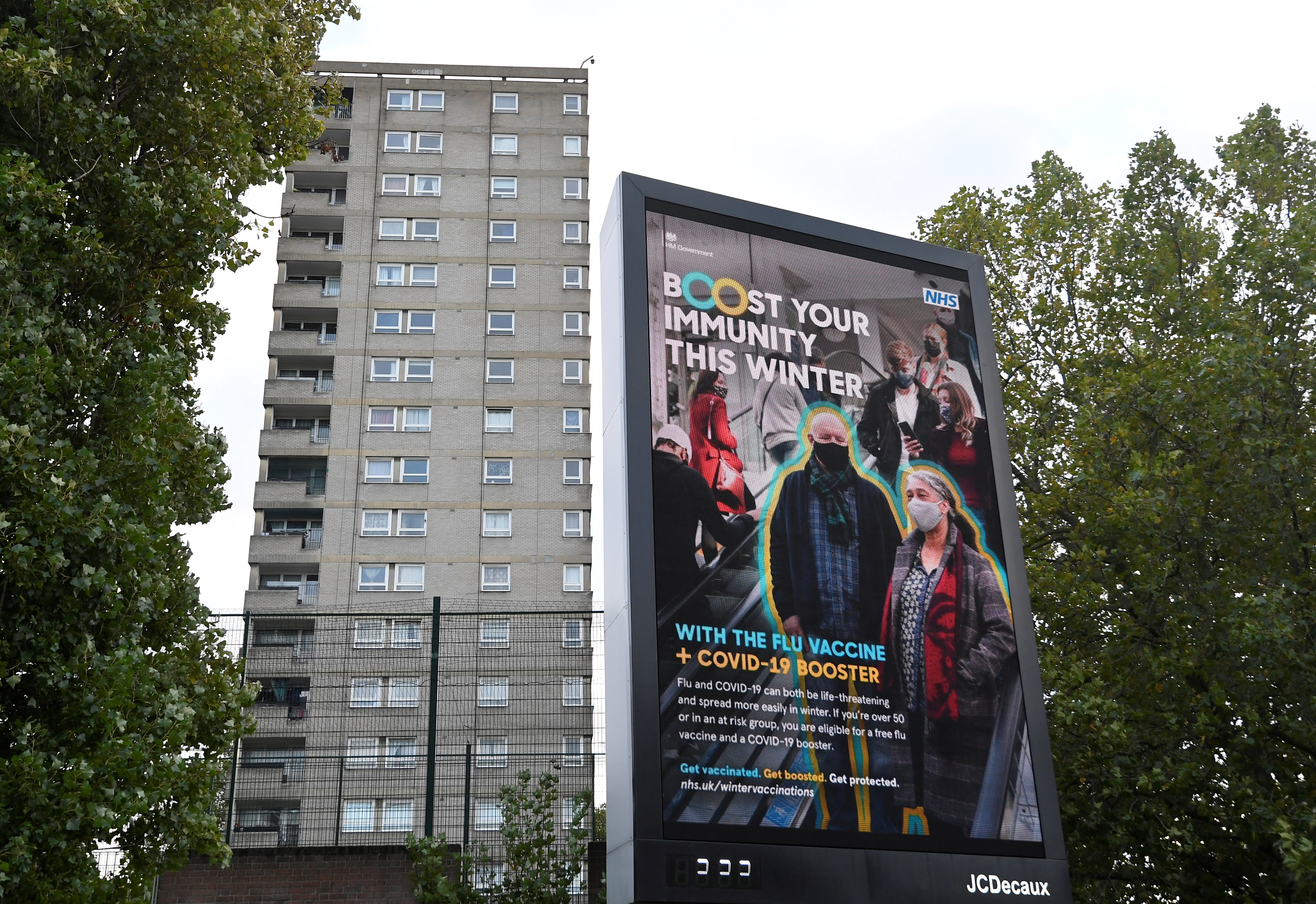 An NHS COVID-19 vaccination health campaign advertisement is displayed near a housing block, amidst the spread of the coronavirus disease (COVID-19), in London