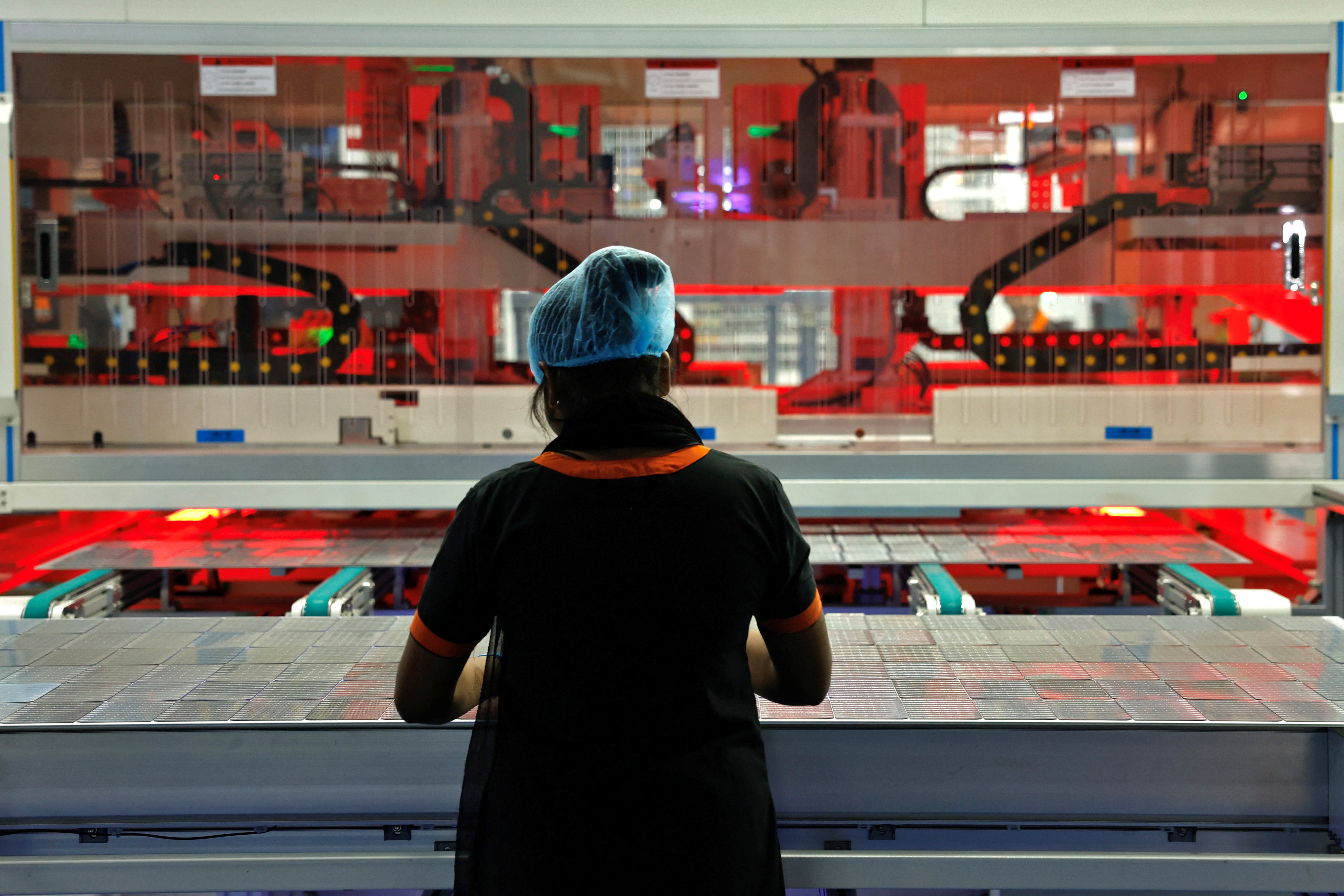 A female technician works on the assembly line at a solar panel manufacturing hub, in Greater Noida