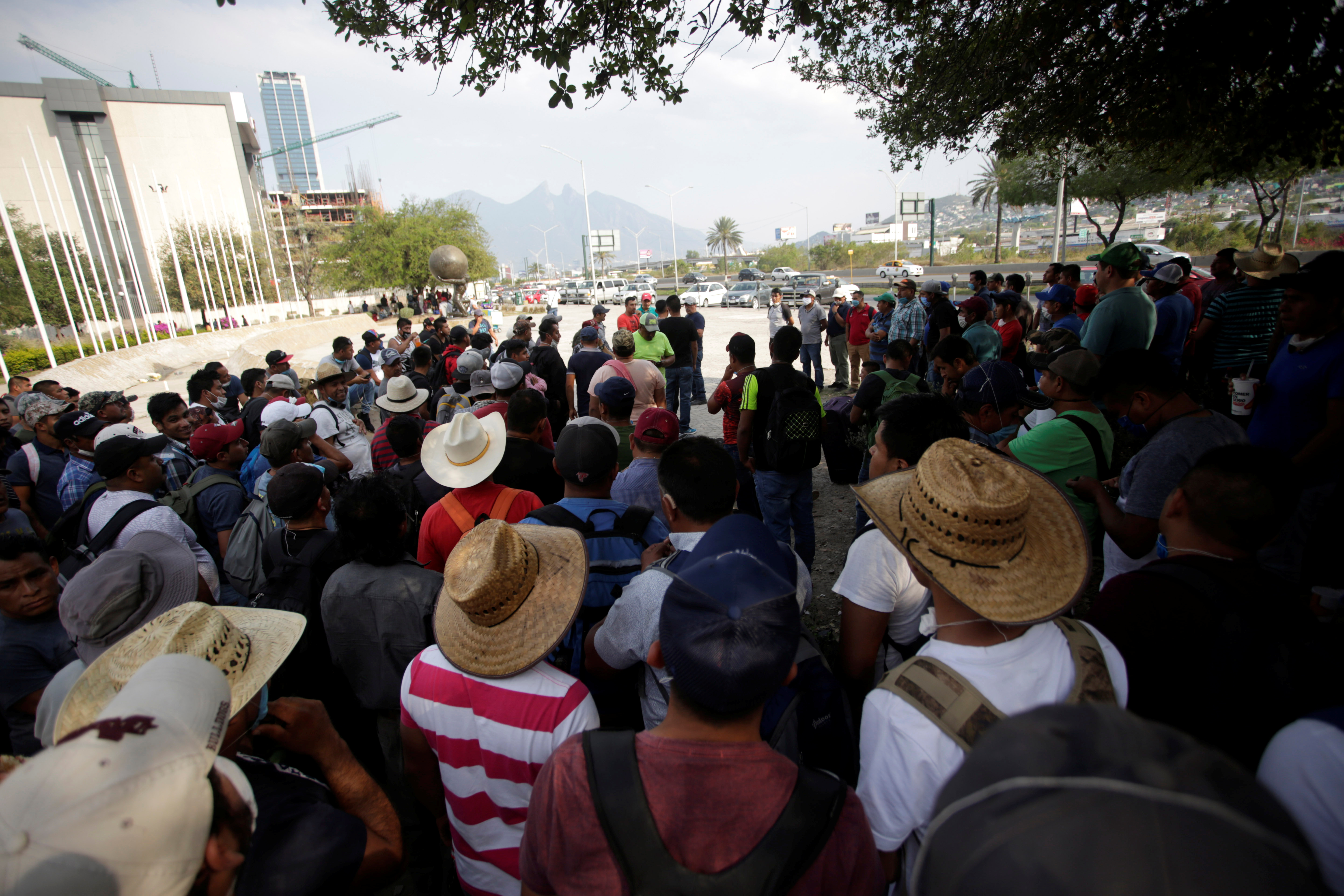 Migrants seeking for a U.S. work visa are seen waiting in a park of downtown of Monterrey