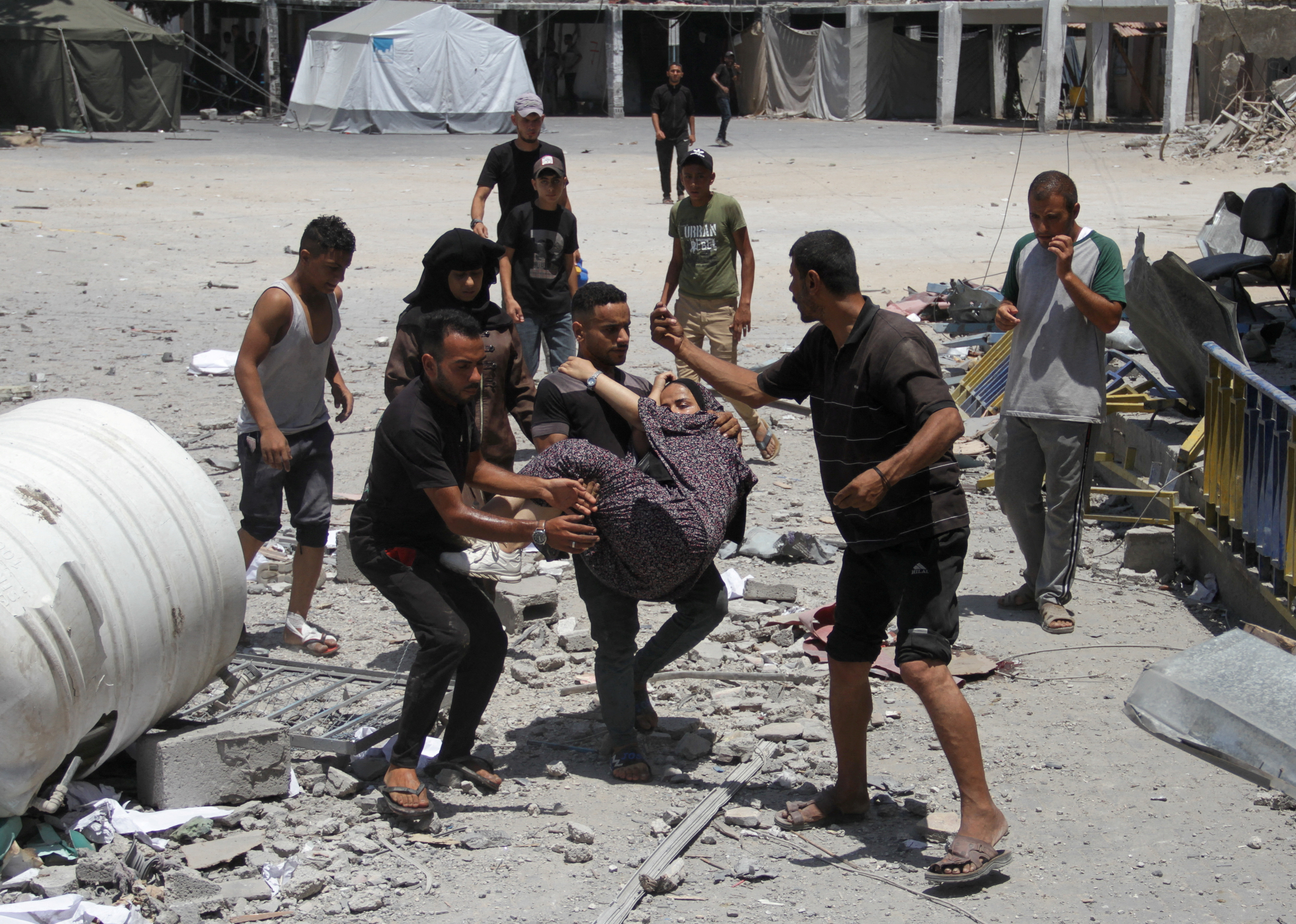 Palestinians search for casualties outside UNRWA headquarters, following an Israeli strike, in Gaza City