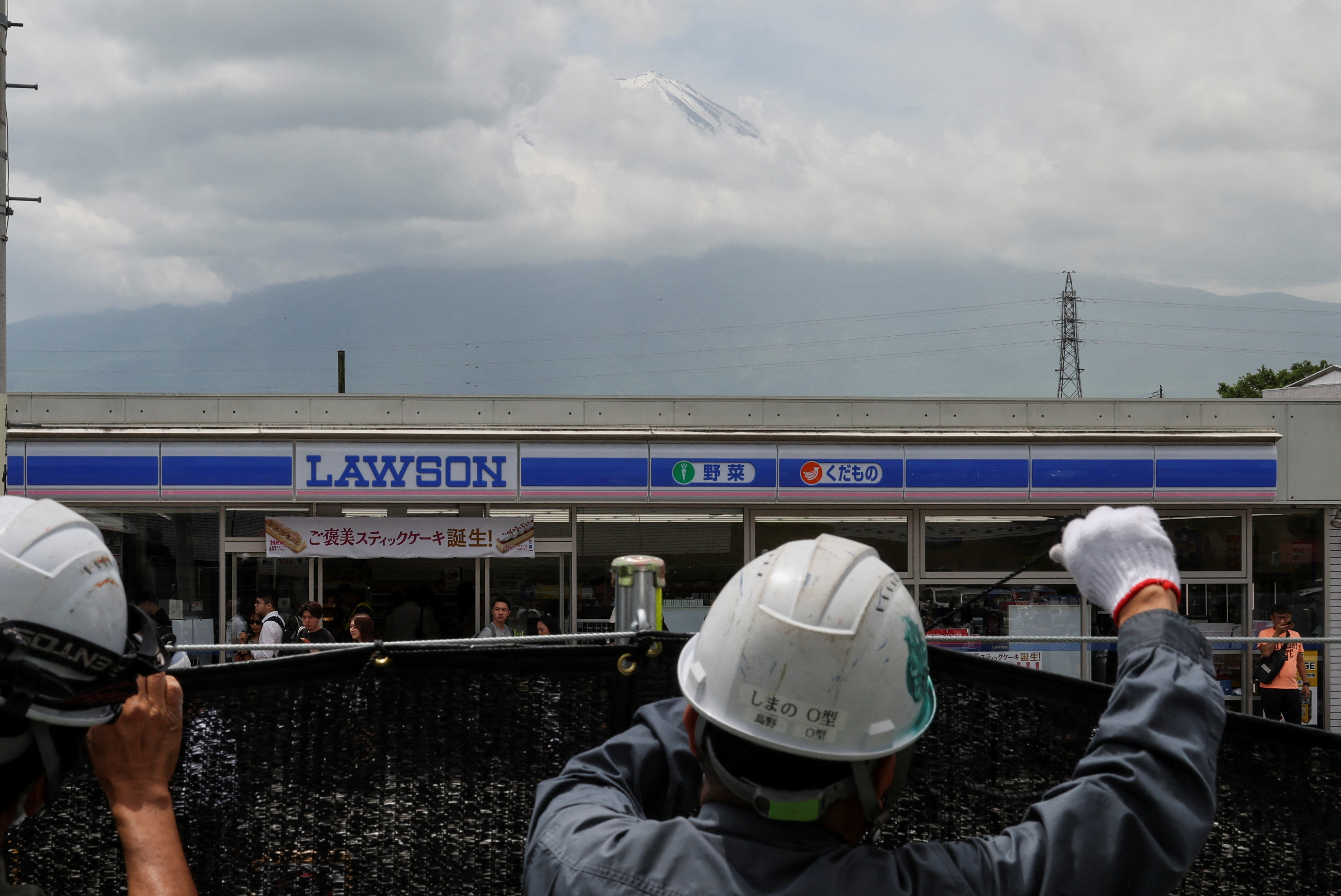Workers erect a barrier to block the view of a popular Mount Fuji photo spot, in Fujikawaguchiko town