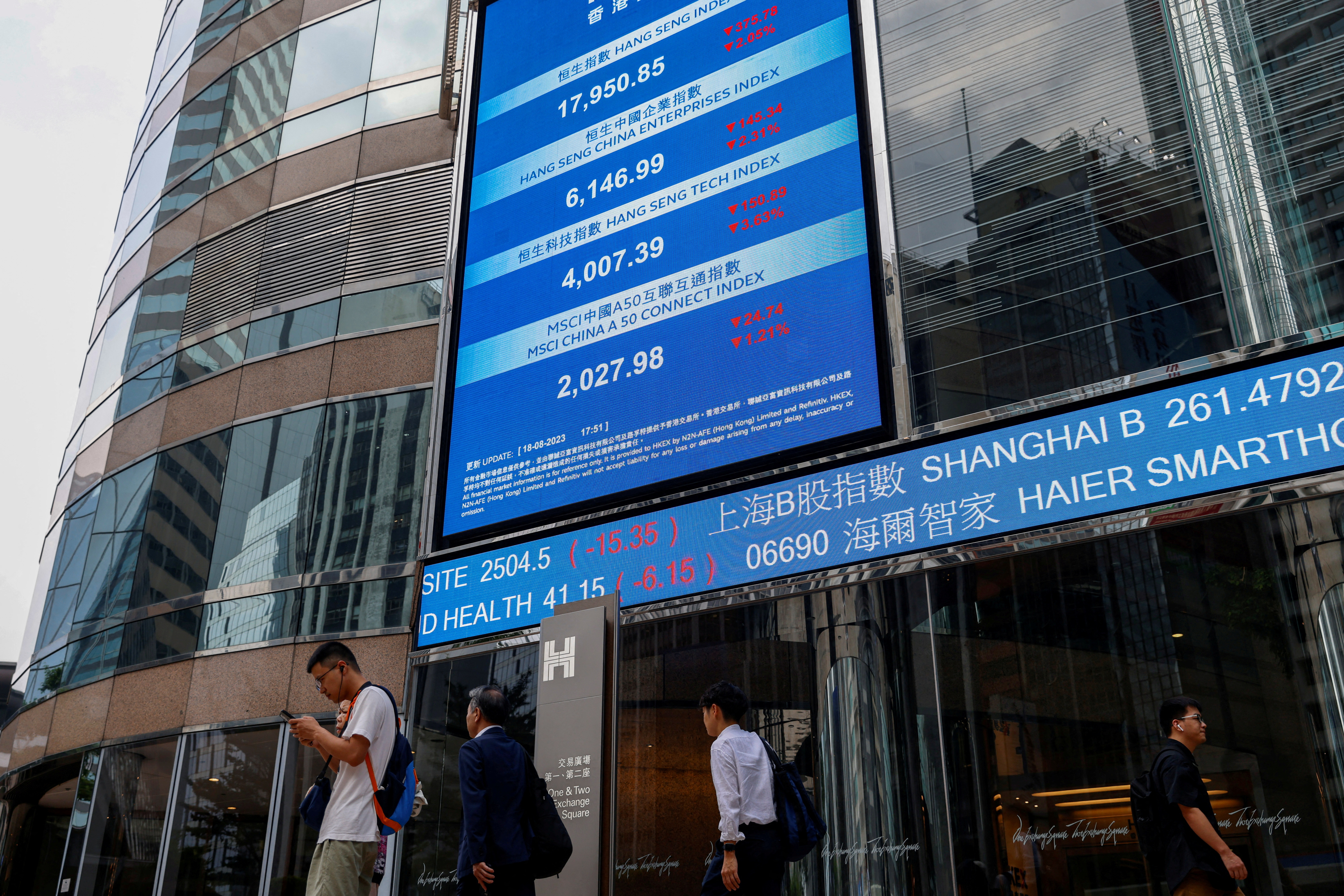 Screens showing the Hang Seng stock index and stock prices are seen outside Exchange Square, in Hong Kong
