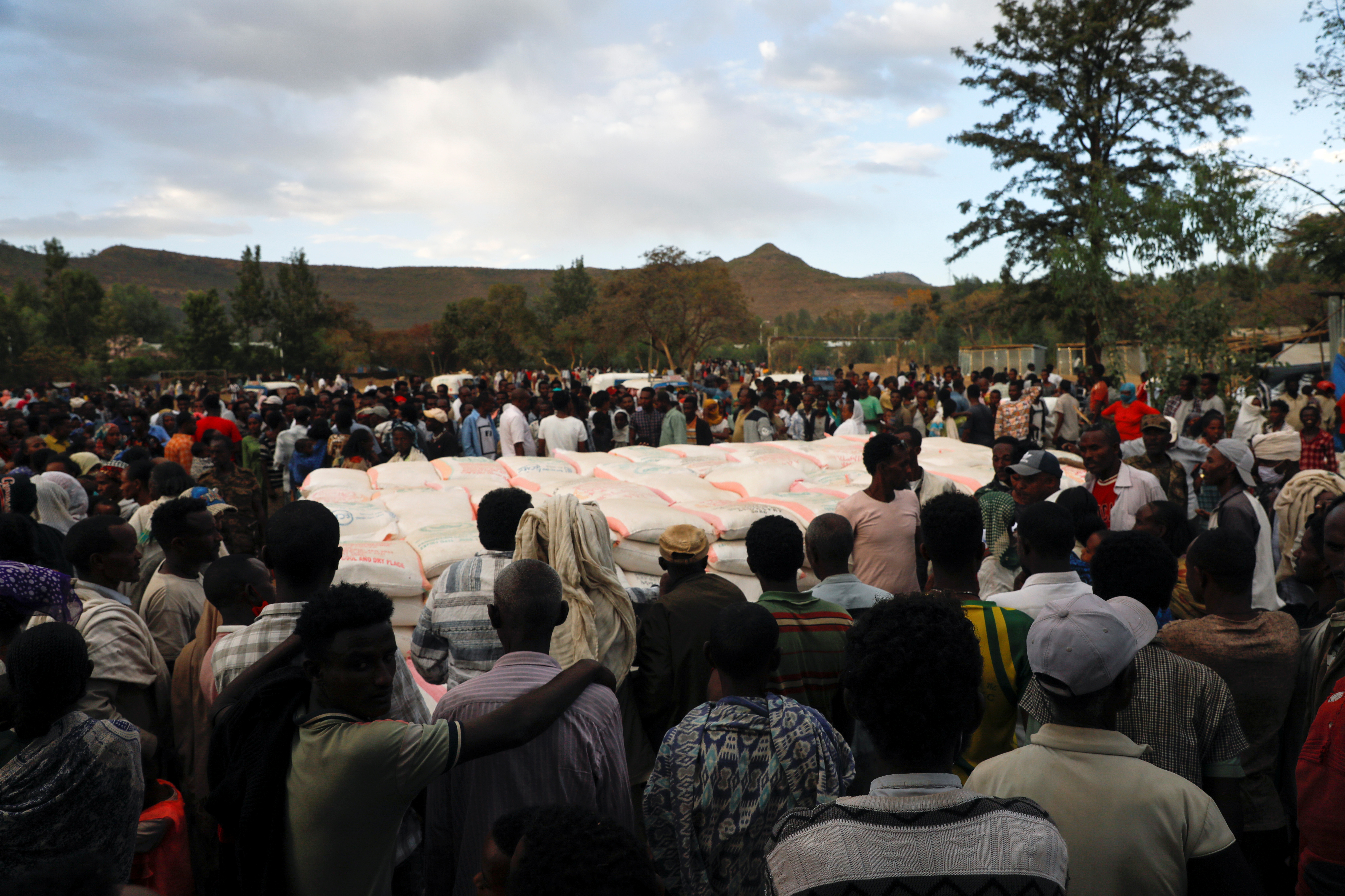 People stand in line to receive food donations, at the Tsehaye primary school in Shire