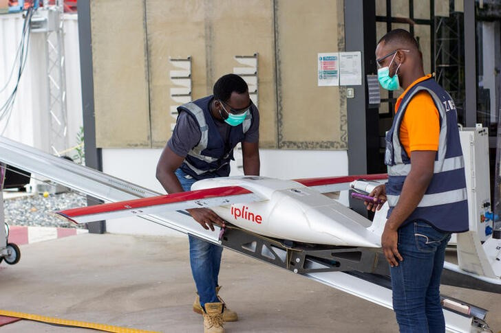 Операторы полетов проводят предполетную проверку дрона в Гане