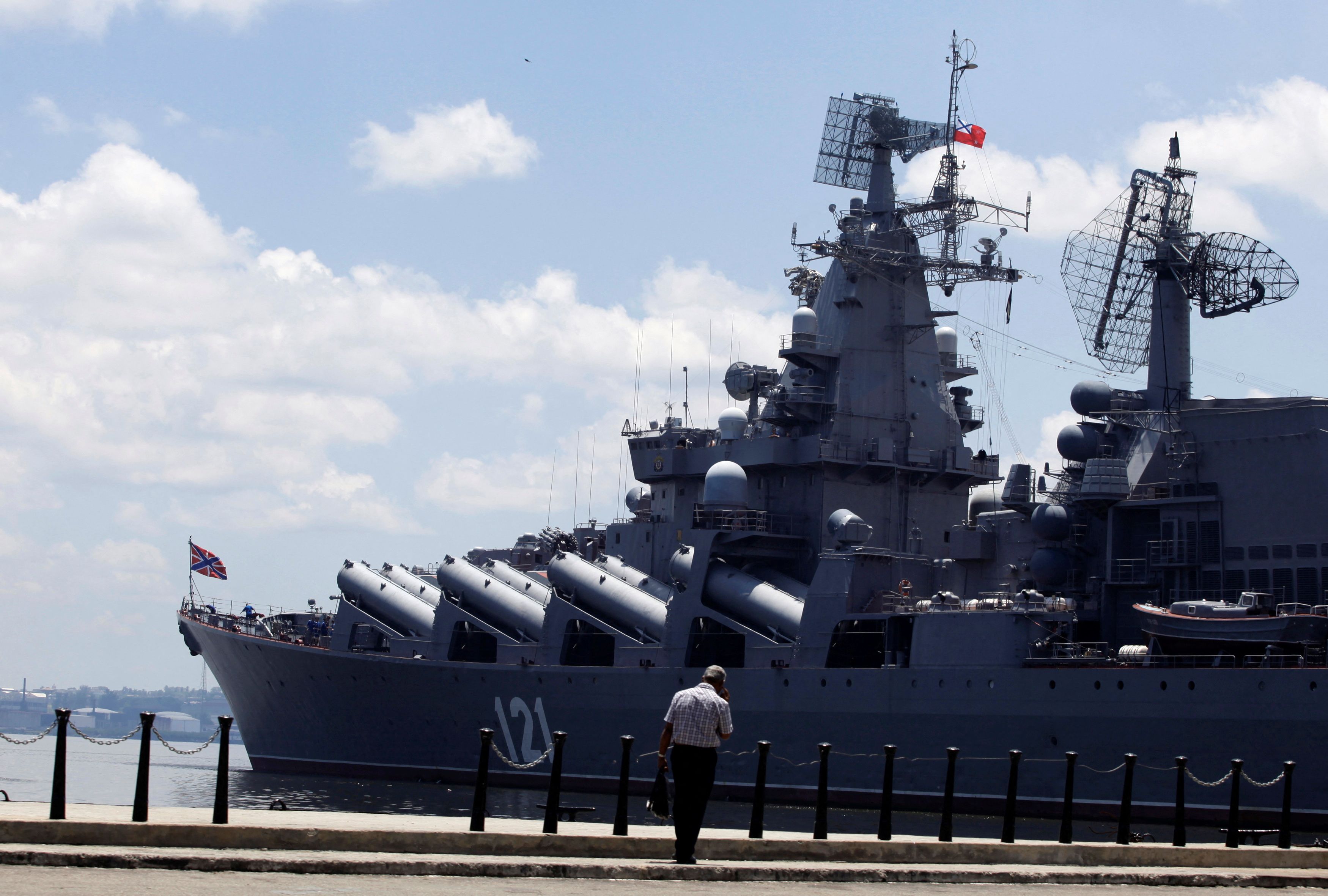 A man walks beside the Russian Moskva Guided Missile Cruiser docked at Havana port