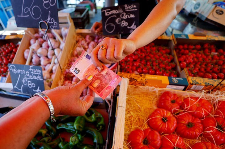 Shoppers paying with 10 euro notes at a local market in Nice