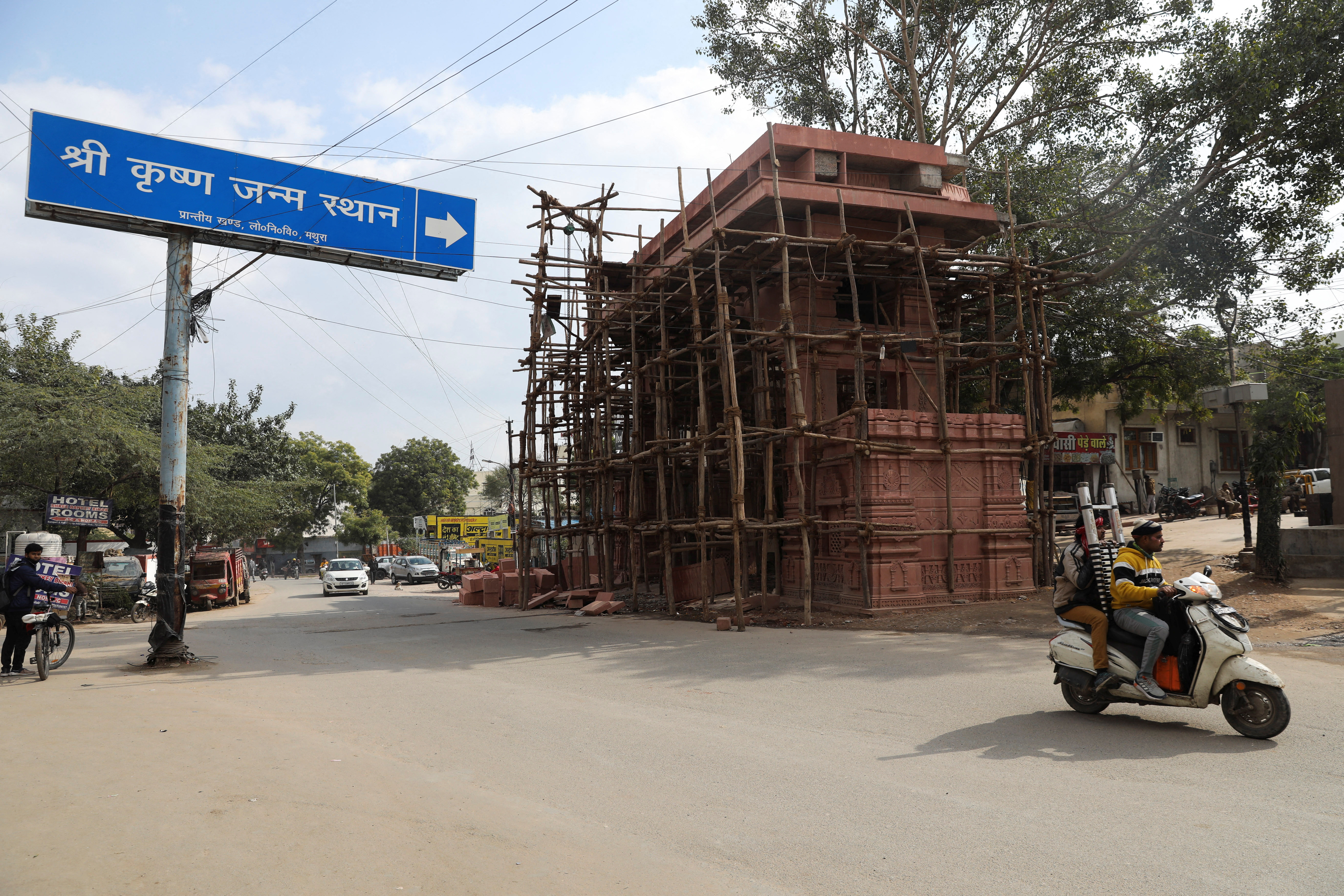 A motor bike passes by an ongoing construction of an entrance to the Hindu temple in Mathura town