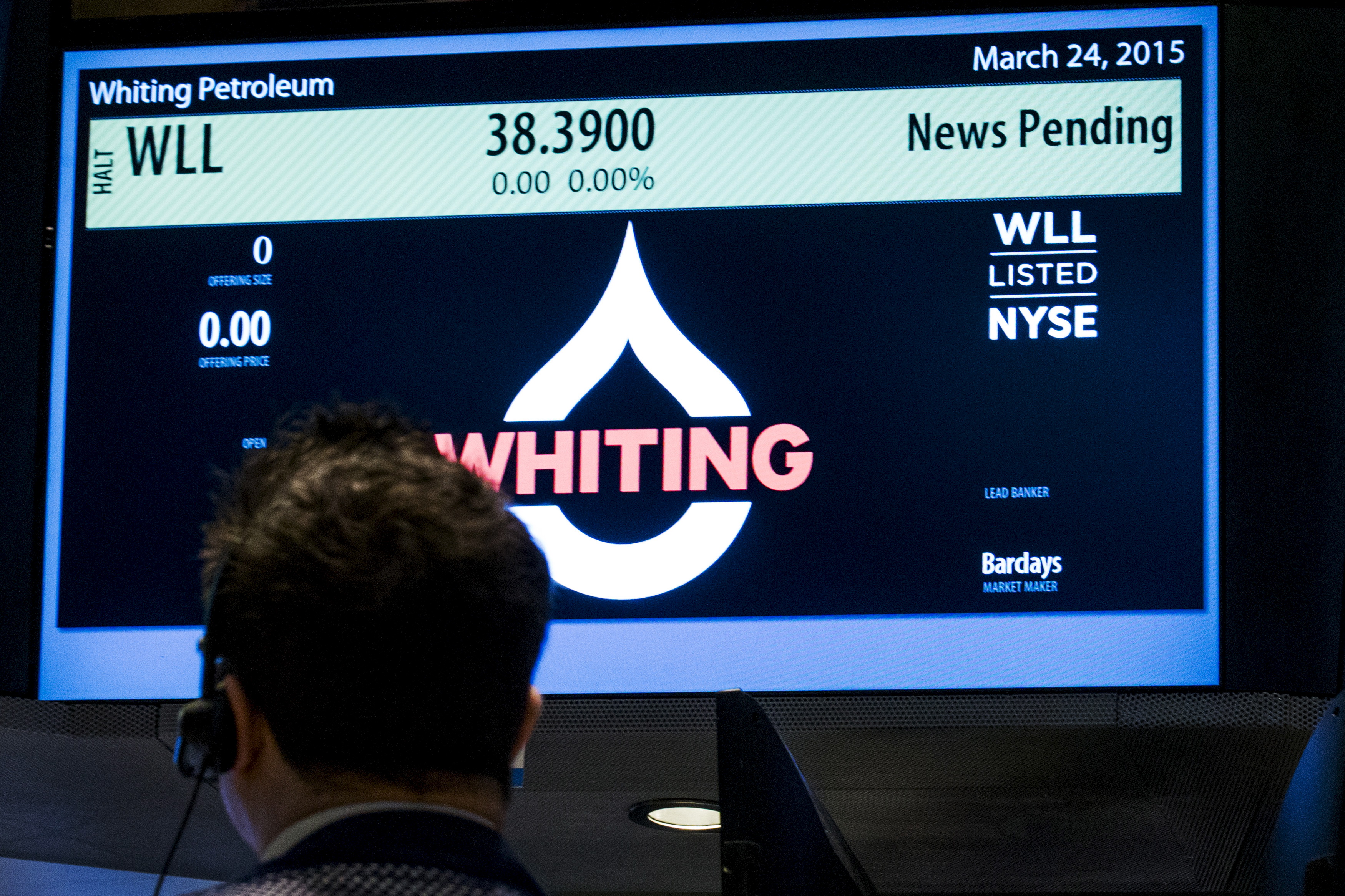 A trader waits for the opening of Whiting Petroleum's stock at the post where it is traded on the floor of the New York Stock Exchange
