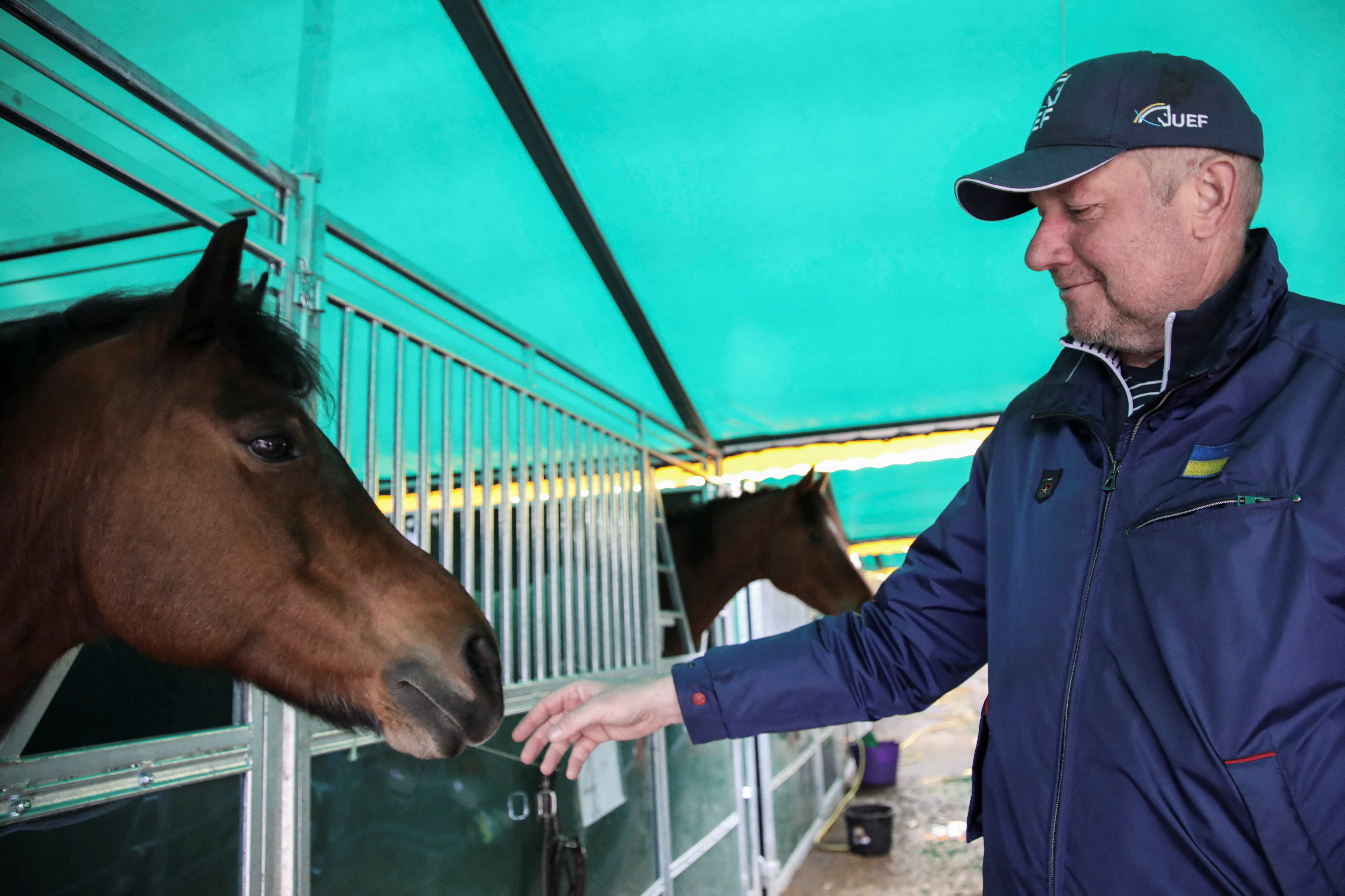 Parkhomchuk, fundador de la Fundación de Caridad de la Federación Ecuestre Ucraniana acaricia un caballo en un establo improvisado, en la región de Lviv