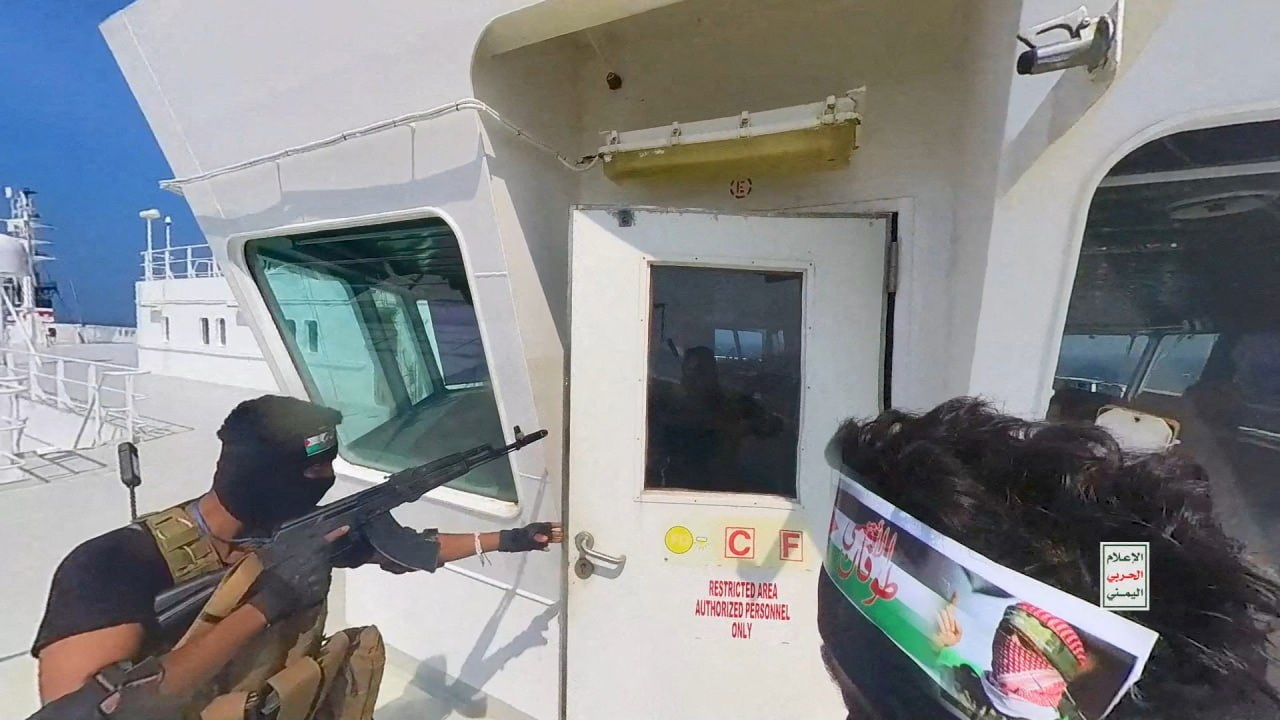 Houthi fighters open the door of cockpit on the cargo ship Galaxy Leader in the Red Sea