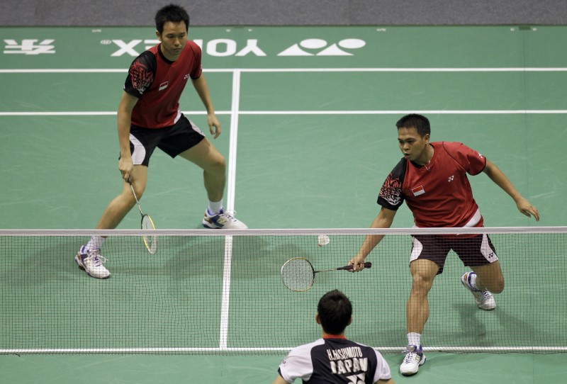 Kido of Indonesia returns a shot to Hashimoto and Hirata of Japan, as his partner Setiawan watches during their men's doubles match in the quarter-final round of the Thomas Cup badminton championship in Wuhan