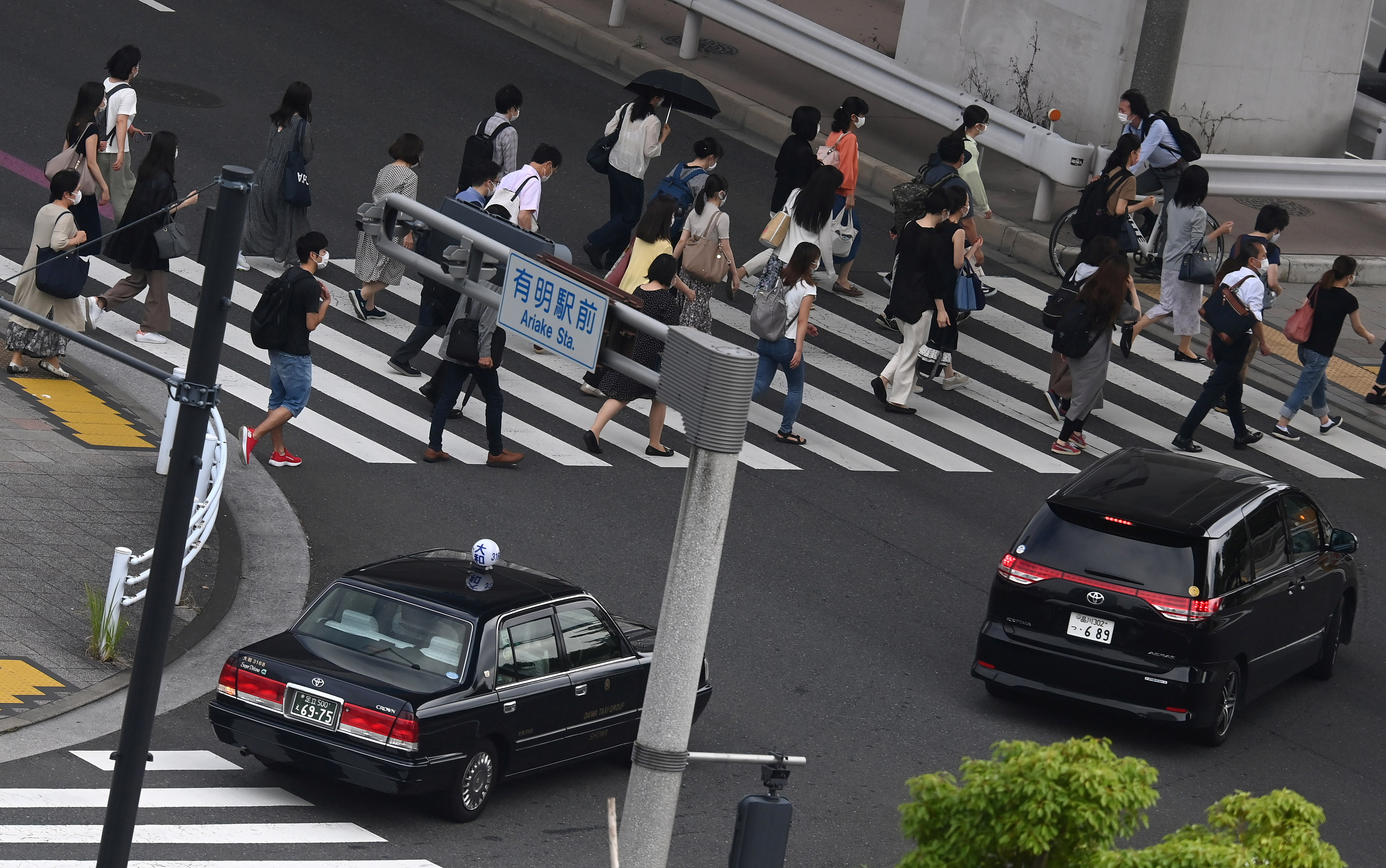 Workers cross a road during the morning rush hour in Tokyo