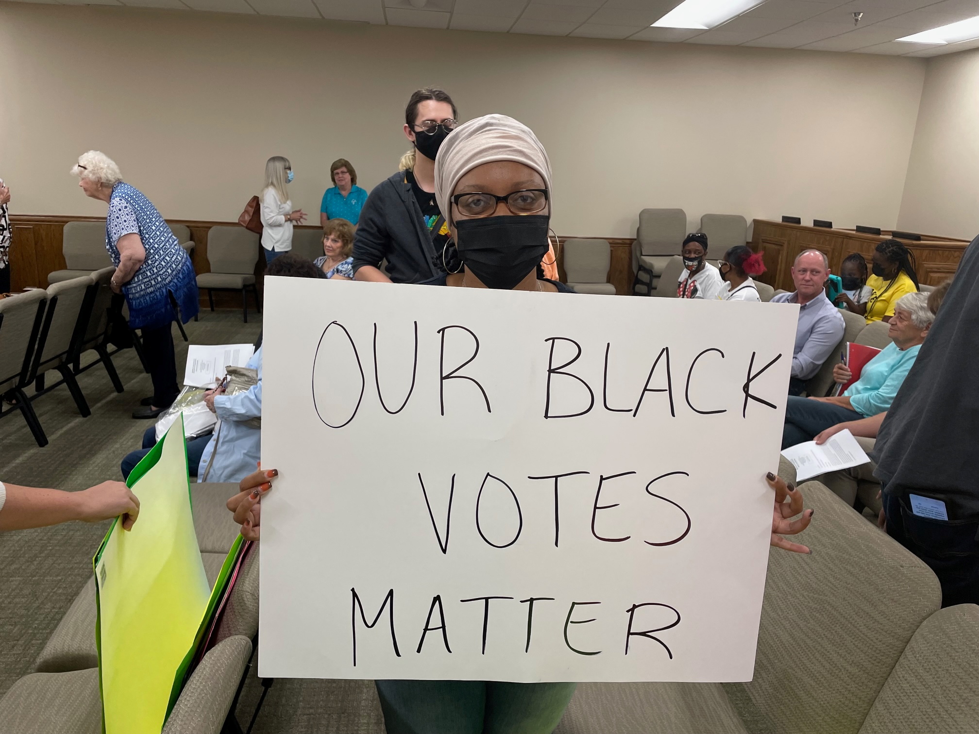Yoshunda Jones, a local activist who protested the elimination of Sunday voting, holds up a sign in Spalding County, Georgia, U.S., October 12, 2021. REUTERS/Jim Oliphant