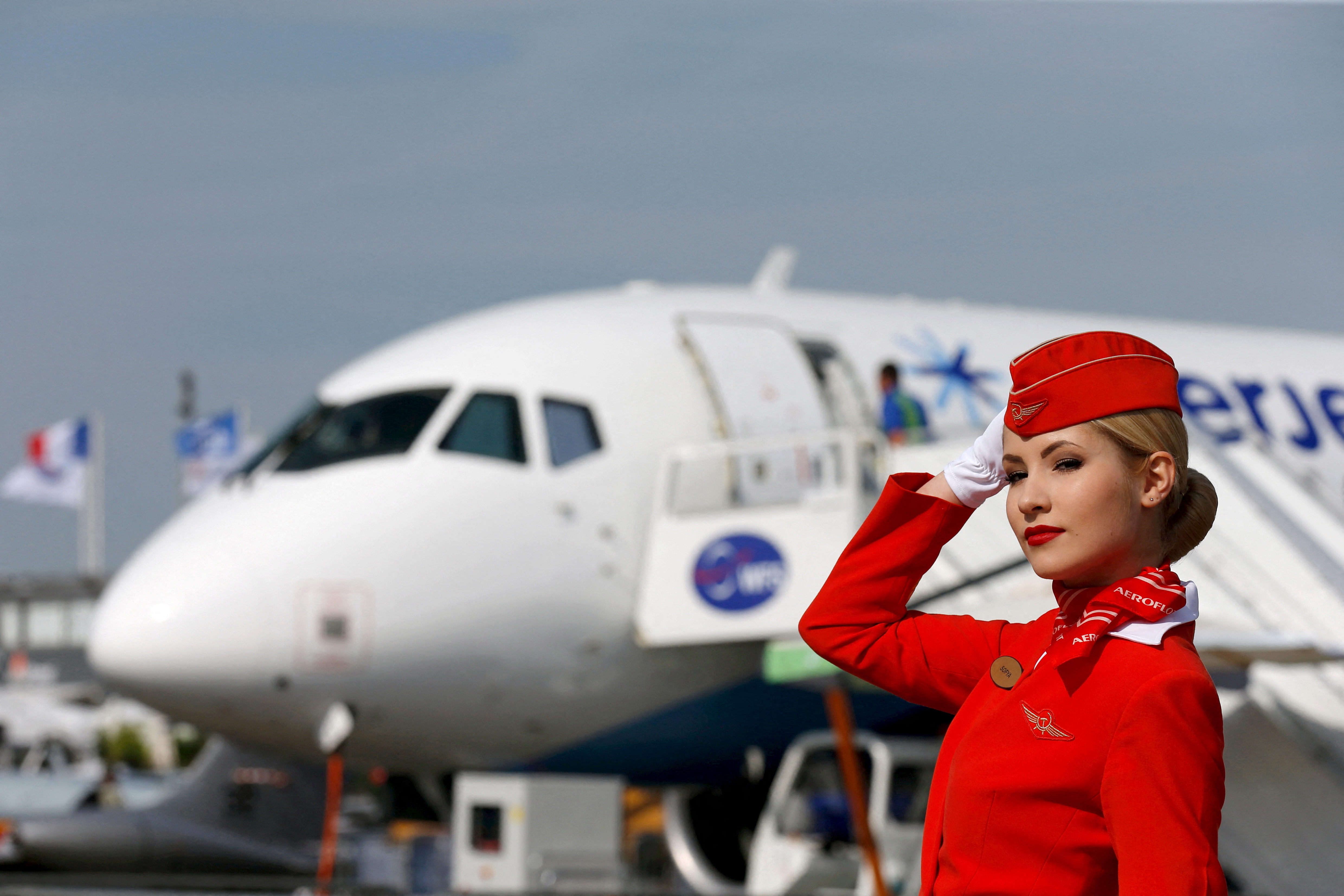 Cabin crew member of Russian carrier Aeroflot poses in front of a Sukhoi Superjet 100 airplane during a photo session at the 51st Paris Air Show at Le Bourget airport near Paris