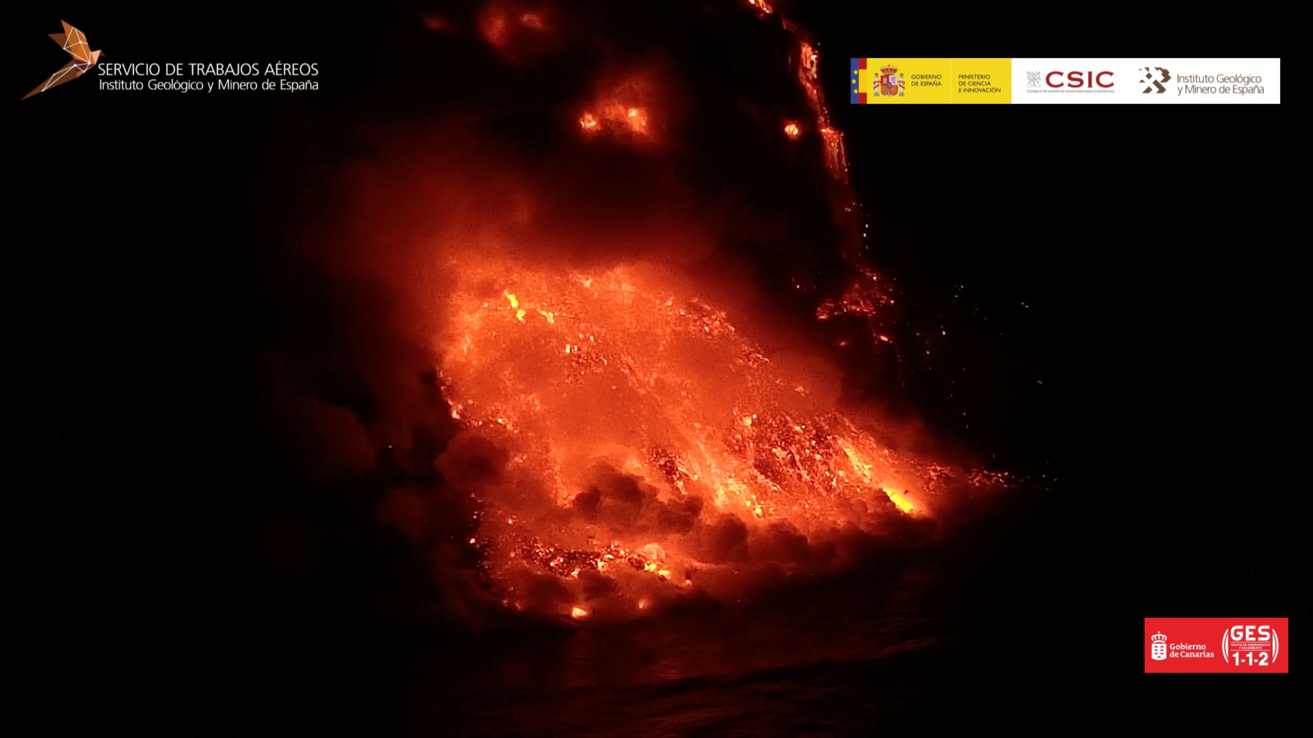Steam rises as lava from the Cumbre Vieja volcano reaches the Atlantic Ocean off the island of La Palma, Spain, September 29, 2021, in this still image taken from video obtained from social media. Video taken September 29, 2021. Mandatory credit Geologico y Minero de Espana (CSIC)/via REUTERS ATTENTION EDITORS - THIS IMAGE HAS BEEN SUPPLIED BY A THIRD PARTY. MANDATORY CREDIT. NO RESALES. NO ARCHIVES. MUST NOT OBSCURE LOGO