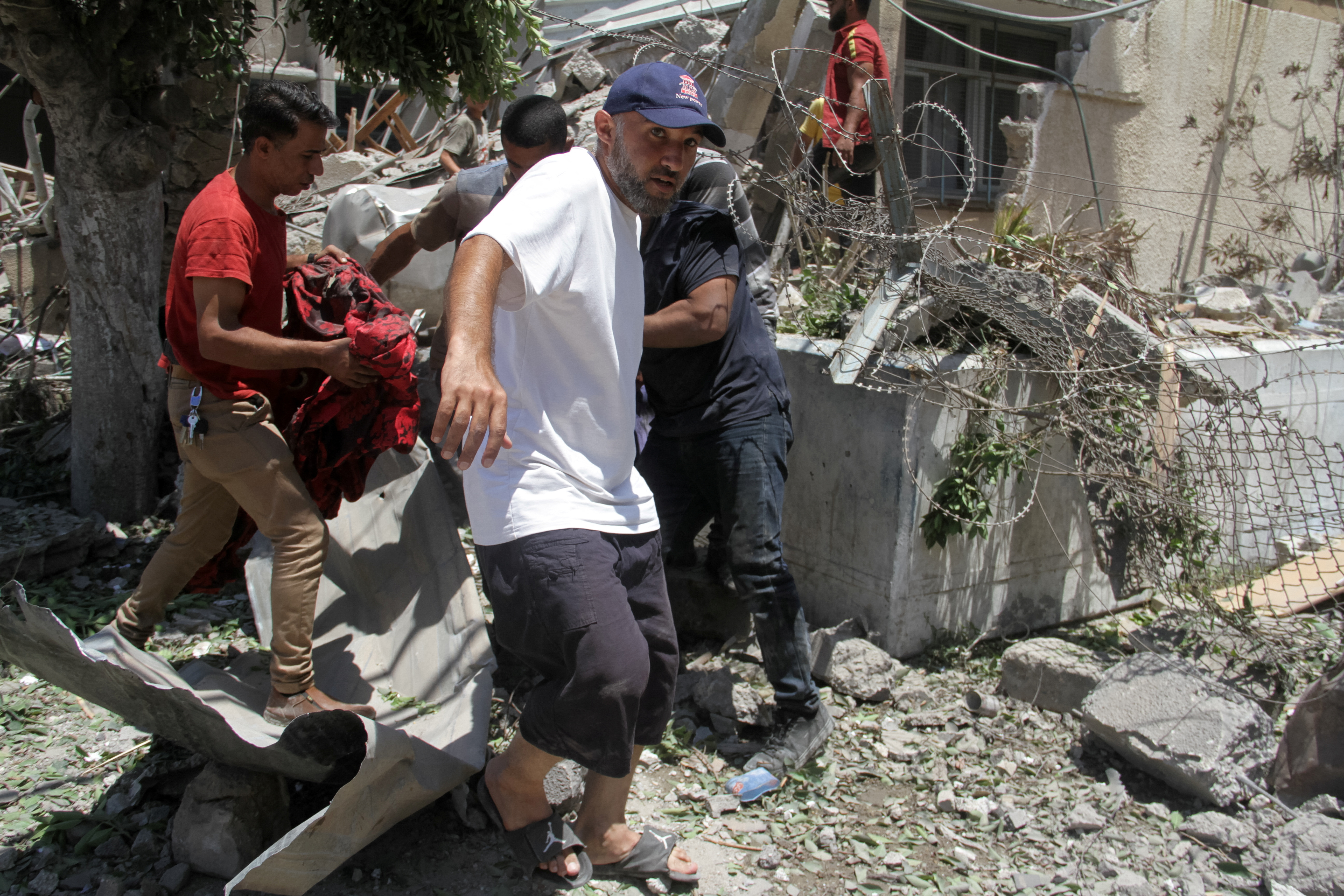 Palestinians search for casualties outside UNRWA headquarters, following an Israeli strike, in Gaza City