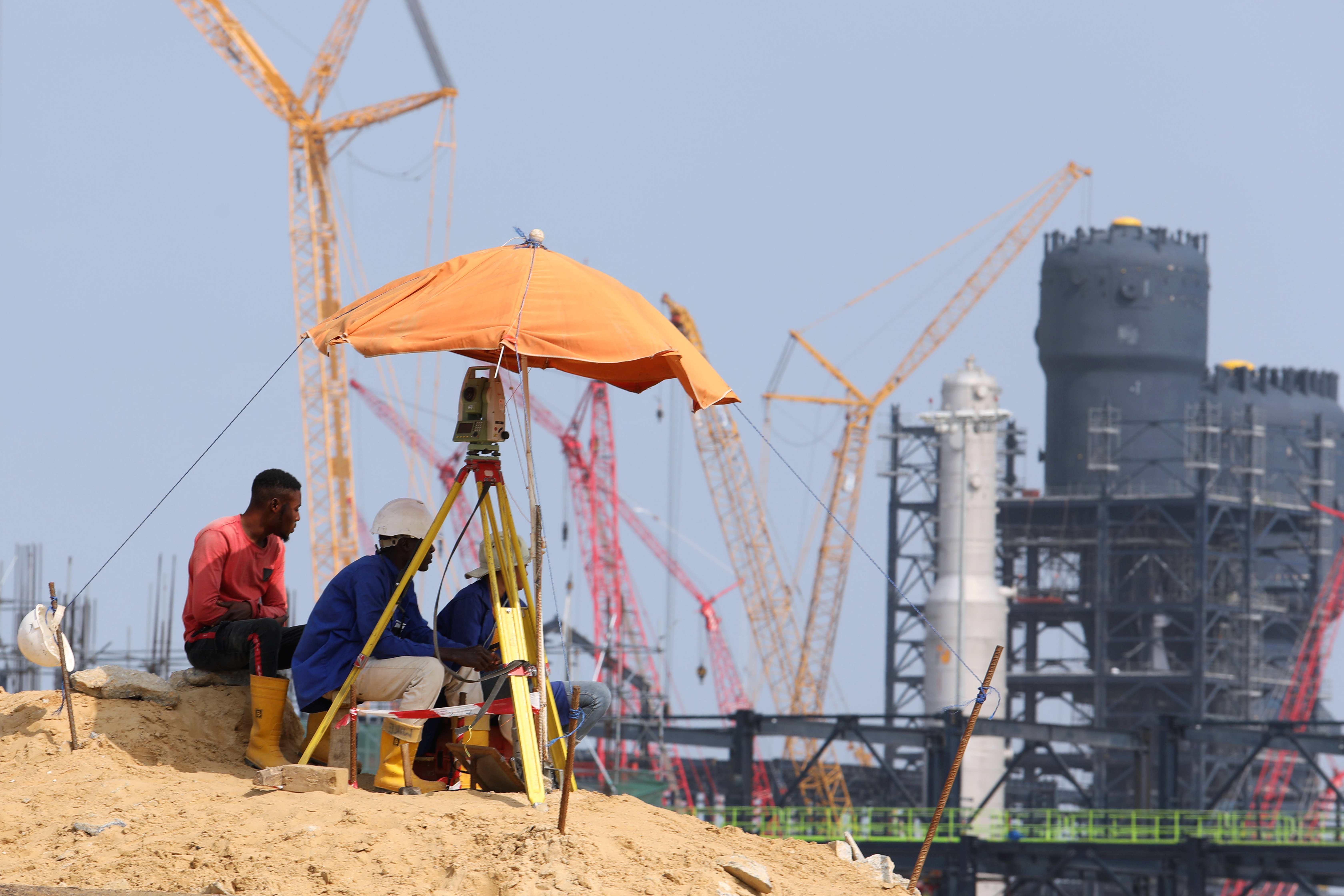 Workers sit at a construction site of the Dangote Refinery in Ibeju Lekki district