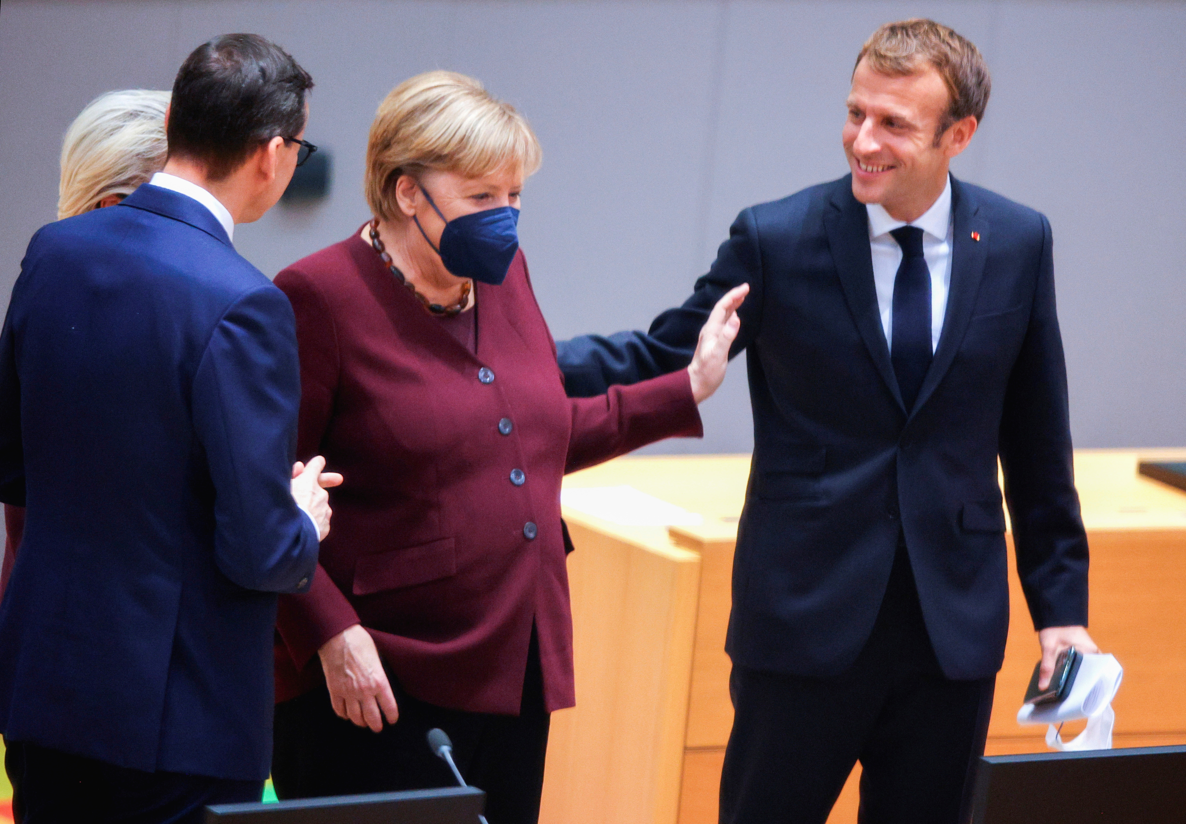 French President Emmanuel Macron speaks with German Chancellor Angela Merkel as European Commission President Ursula von der Leyen speaks with Poland’s Prime Minister Mateusz Morawiecki during a round table meeting at the EU summit in Brussels, Belgium, October 22, 2021. Olivier Matthys/Pool via REUTERS
