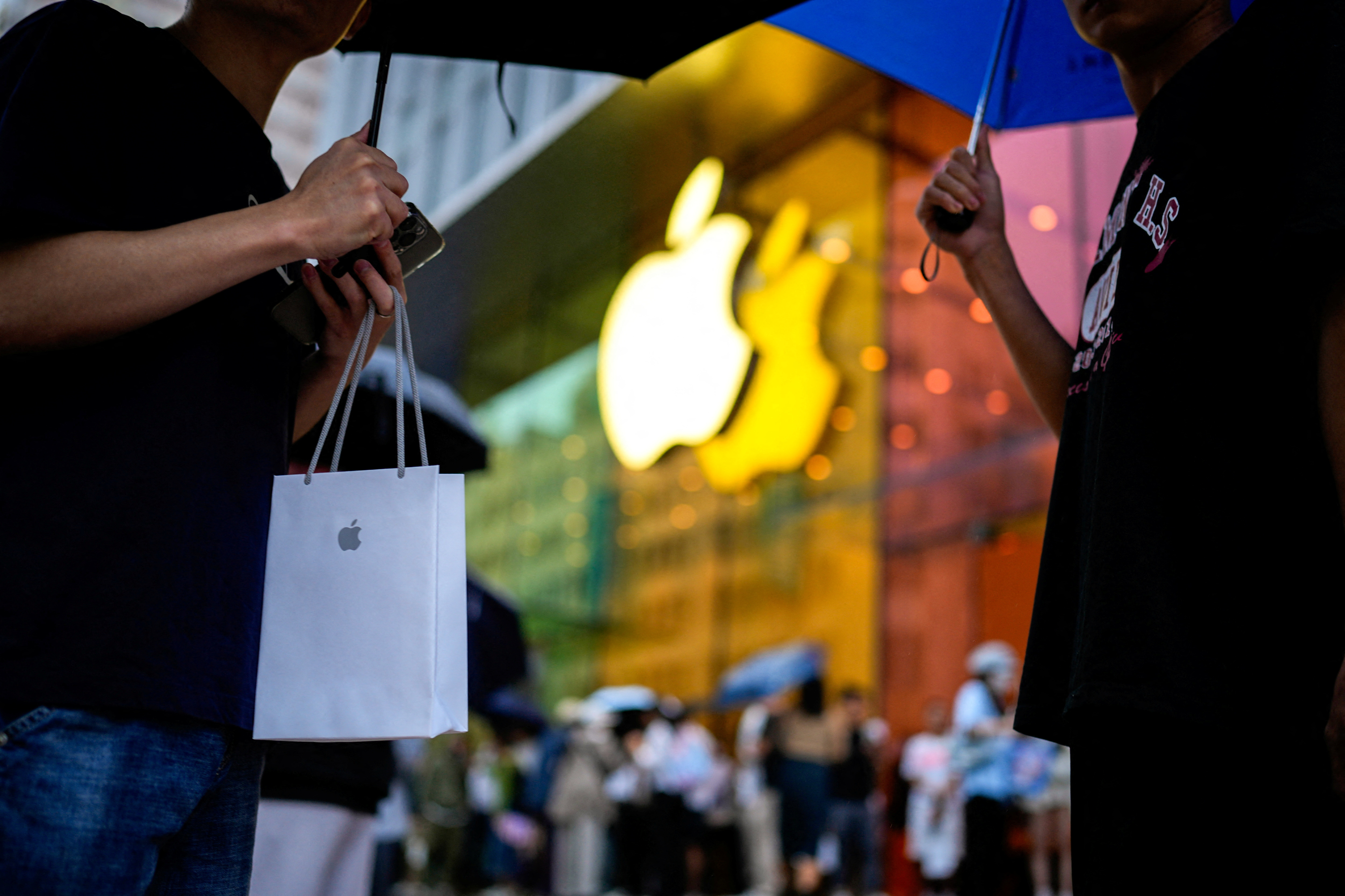 A man holds a bag with a new iPhone inside as Apple's new iPhone 15 officially goes on sale across China, in Shanghai