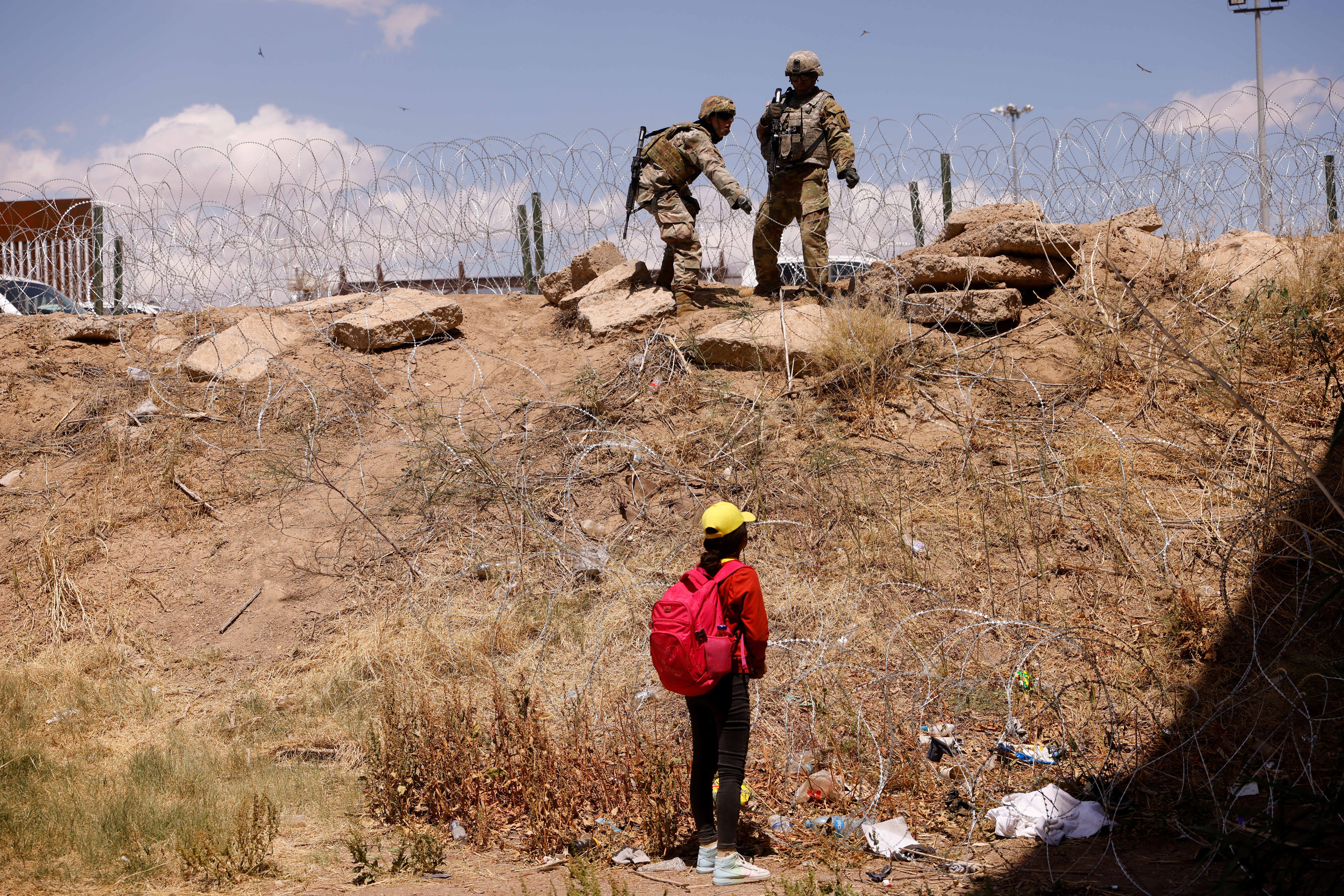 Migrants stand near the Rio Bravo river after crossing the border, to request asylum in the United States, as seen from Ciudad Juarez