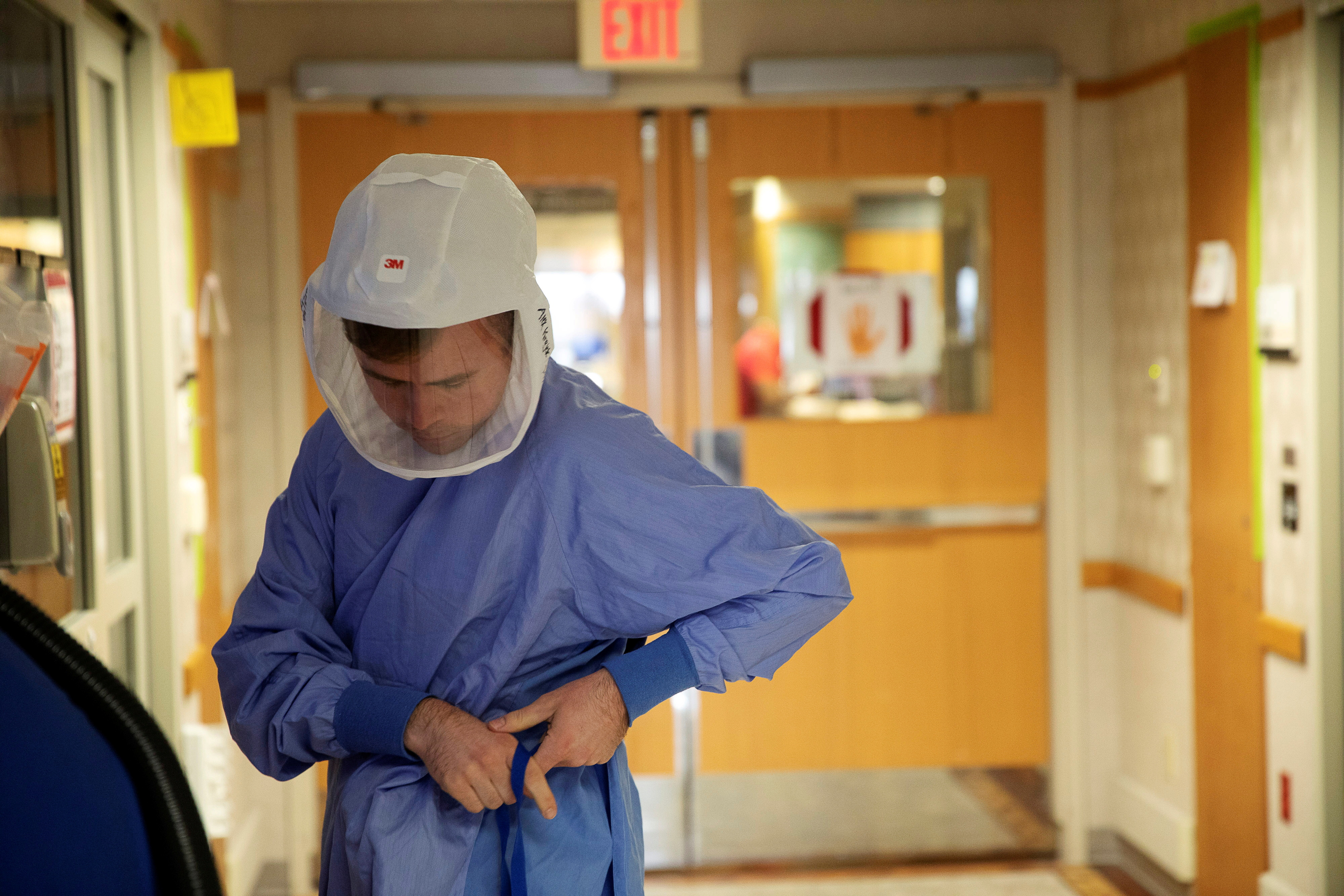 Nurse Alex Krajek puts on PPE as he prepares to enter a patient room in a wing housing coronavirus disease (COVID-19) patients at UW Health University Hospital in Madison, Wisconsin, U.S. November 18, 2020.  REUTERS/Daniel Acker