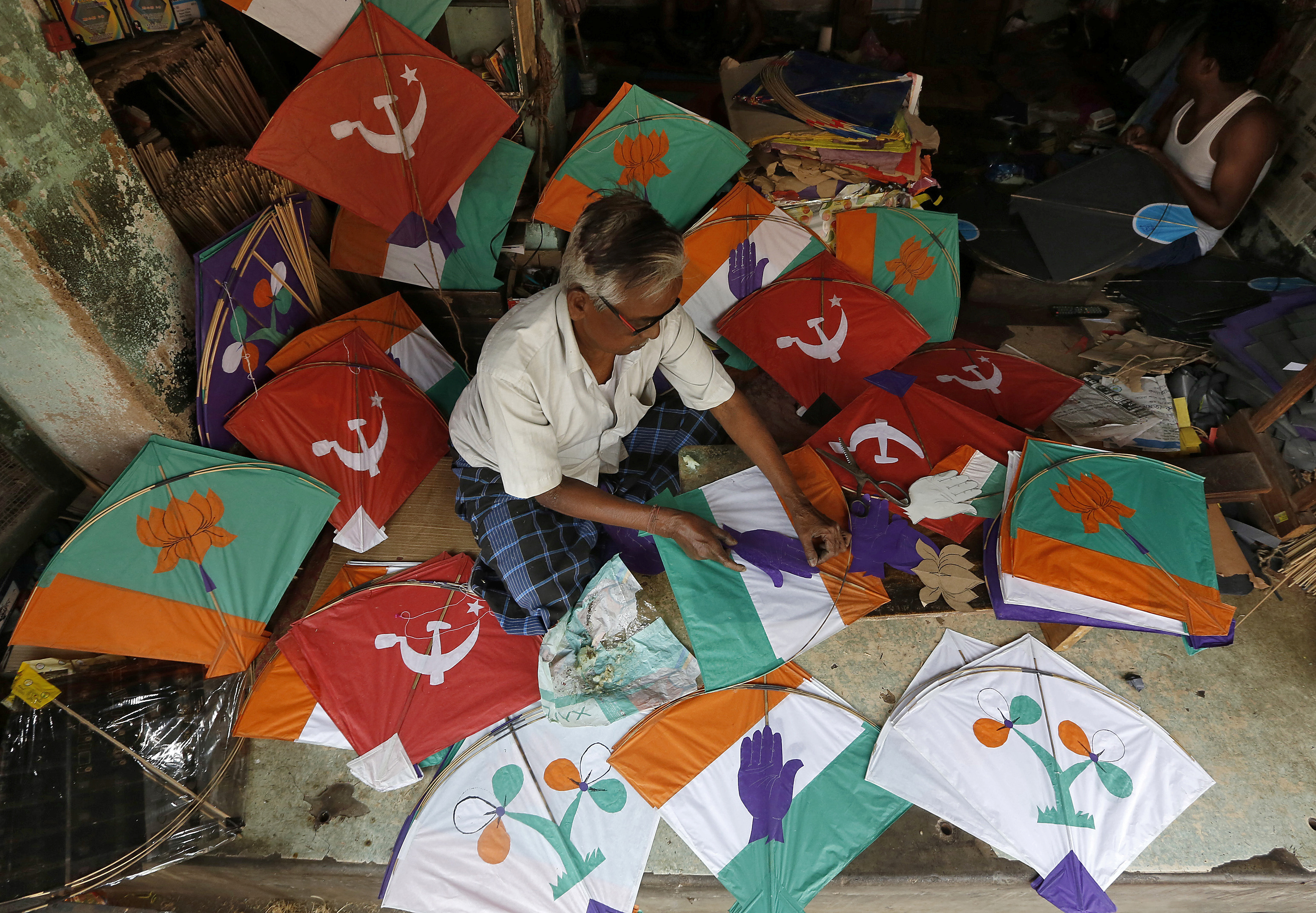 A kite-maker prepares kites with election symbols of Indian political parties at his shop ahead of India's general election