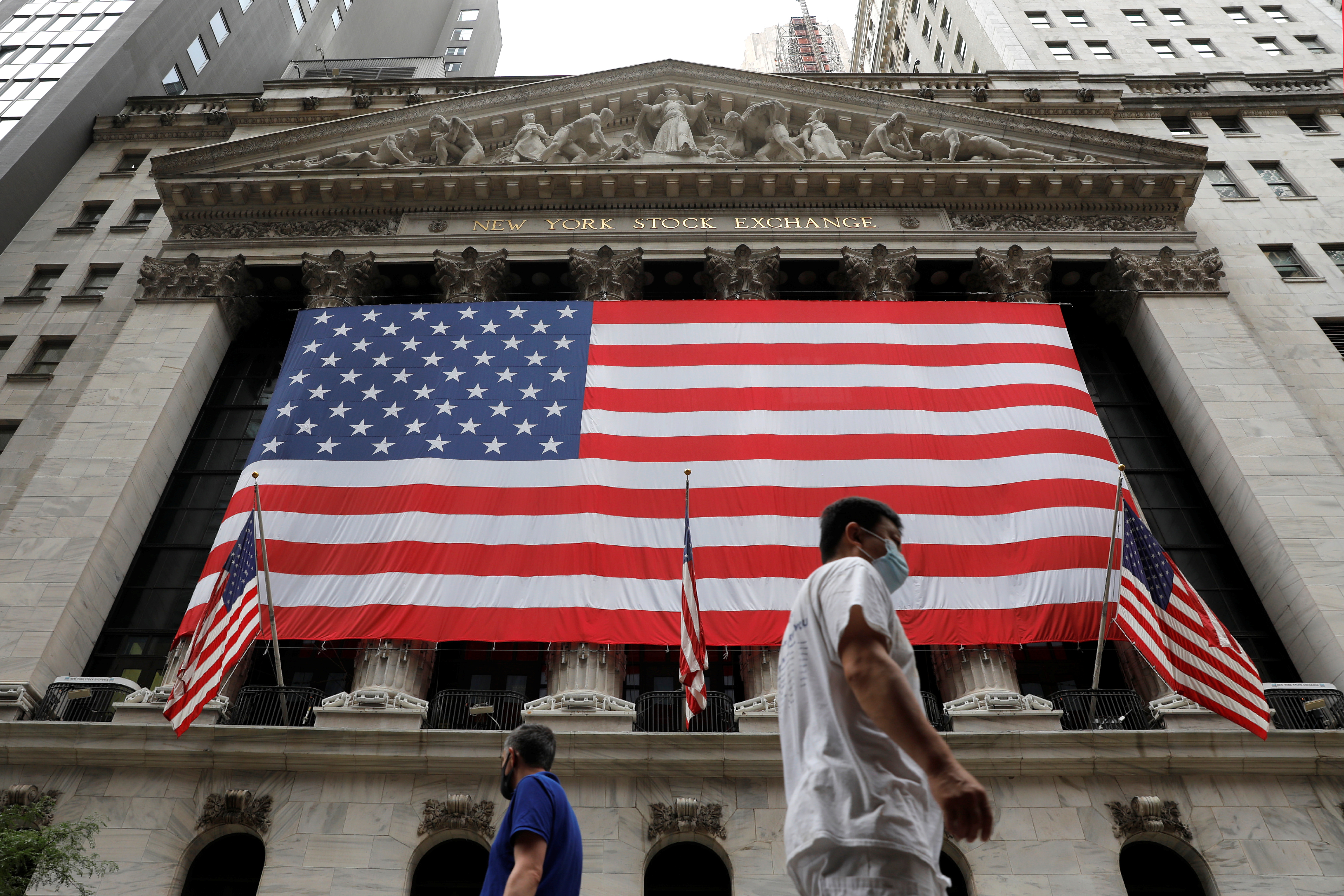 People walk by the New York Stock Exchange (NYSE) in Manhattan, New York City, U.S., August 9, 2021. REUTERS/Andrew Kelly