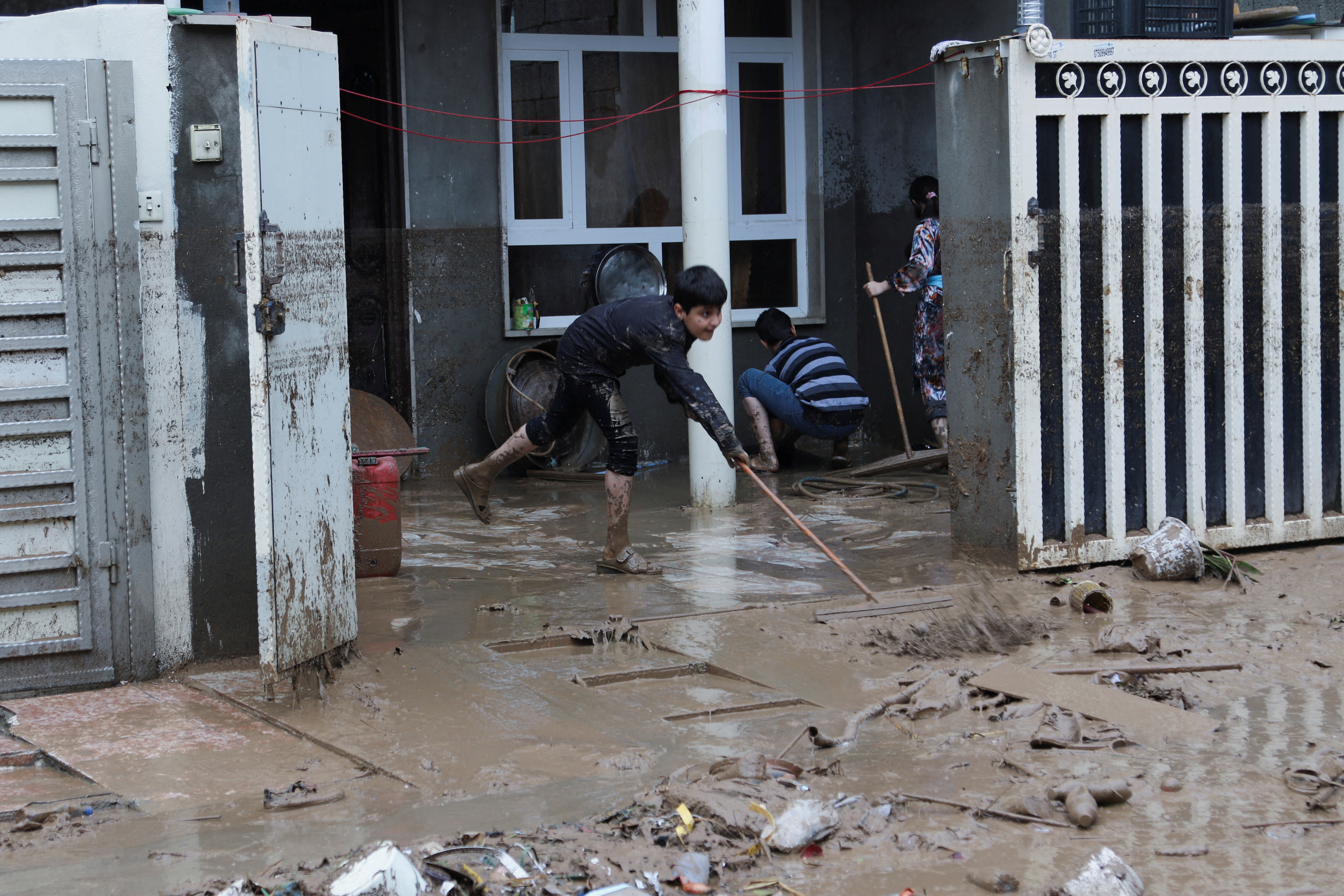 Residents are seen cleaning a home after heavy rainfall in Erbil