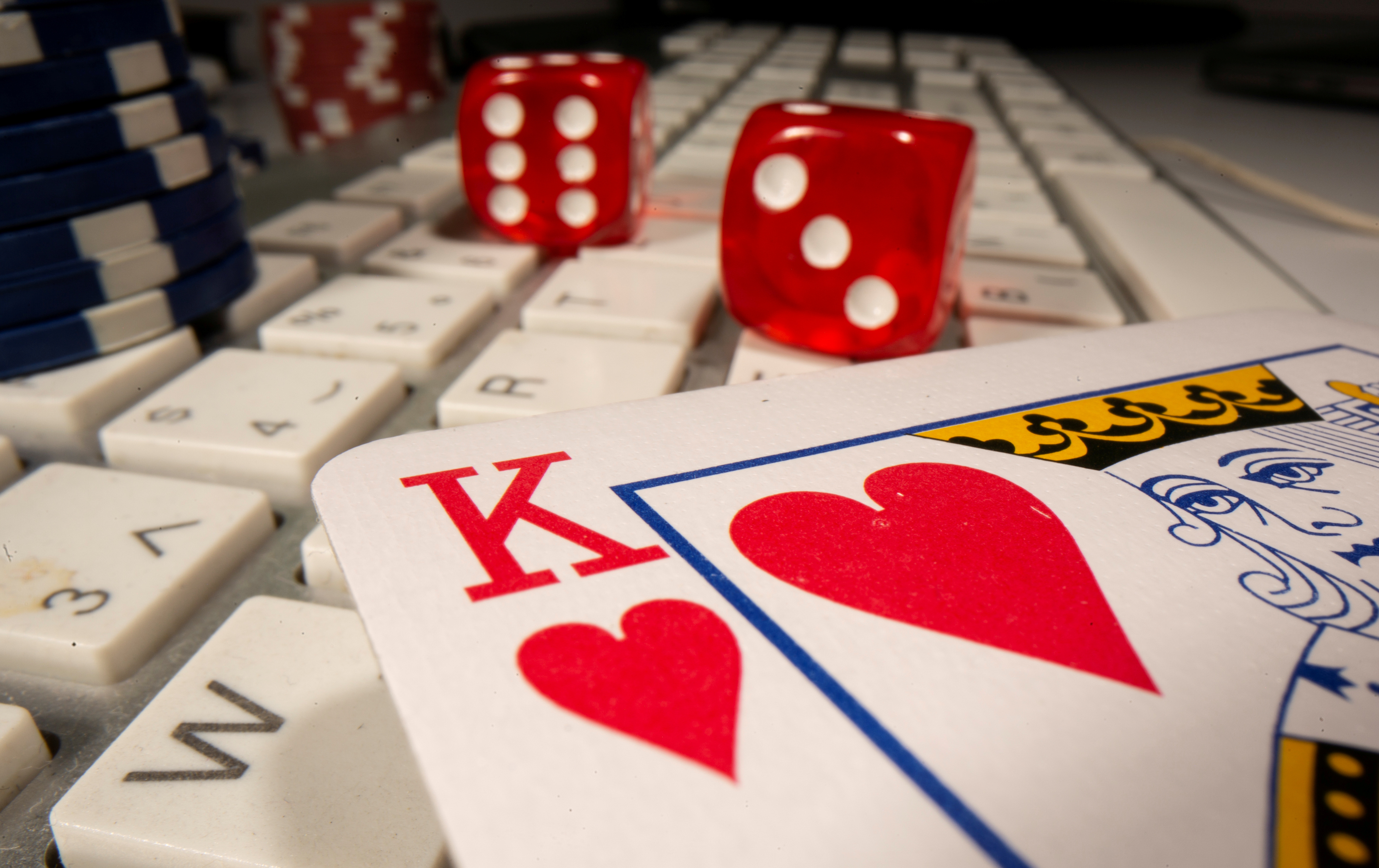 Gambling dice, cards and chips are seen on the keyboard in this illustration picture