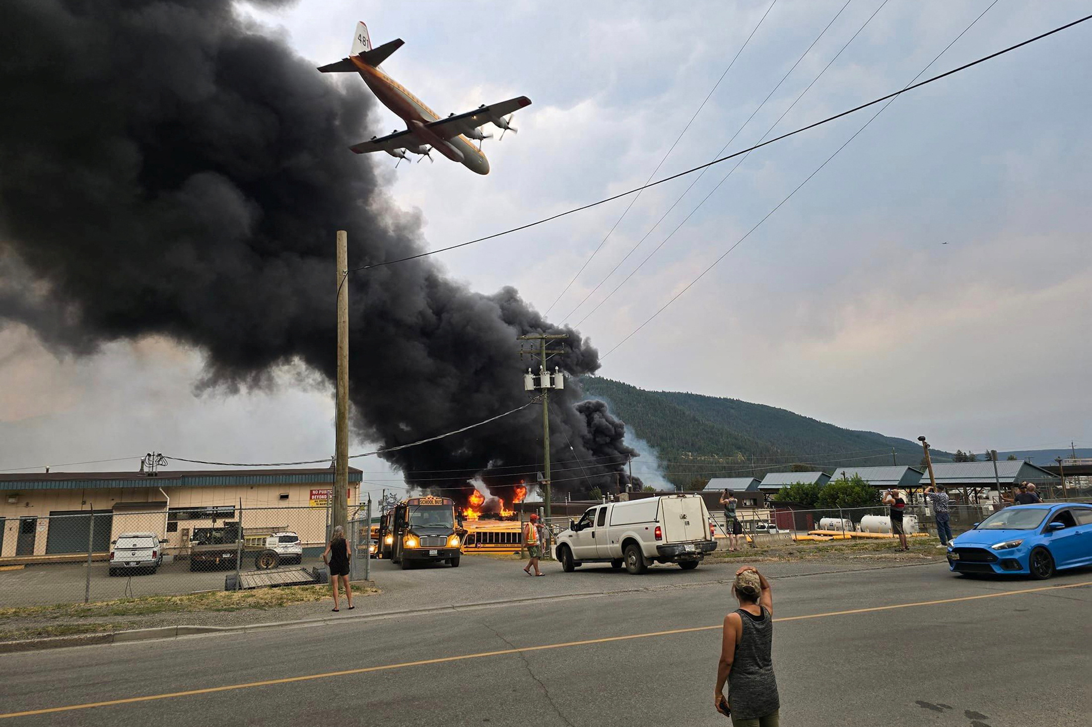 An air tanker flies low over a wildfire burning on the edge of the Cariboo region city of Williams Lake