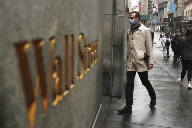 A man wears a protective mask as he walks on Wall Street during the coronavirus outbreak in New York City, U.S., March 13, 2020. REUTERS/Lucas Jackson