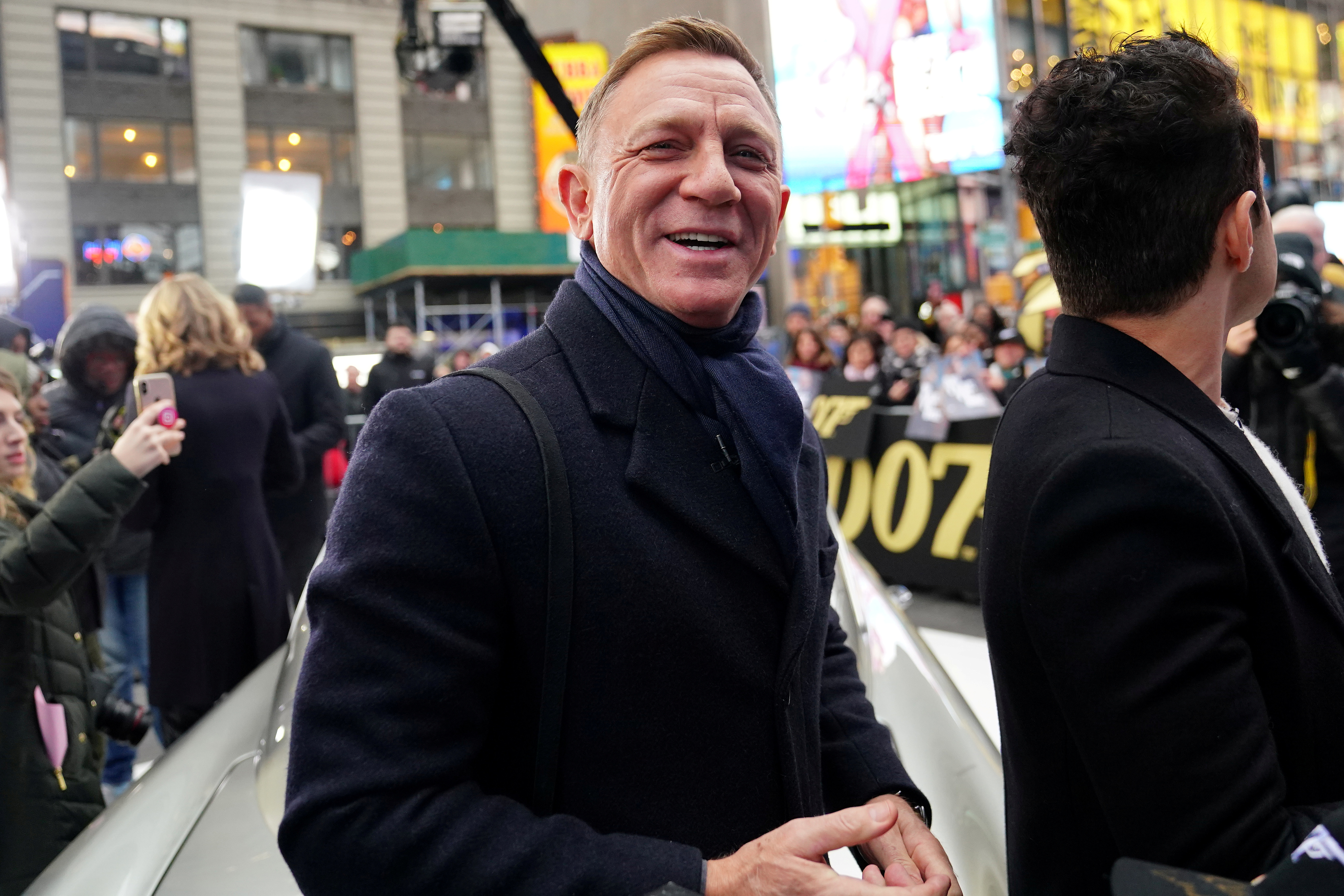 Actor Daniel Craig reacts next to actor Rami Malek during a promotional appearance on TV in Times Square for the new James Bond movie 