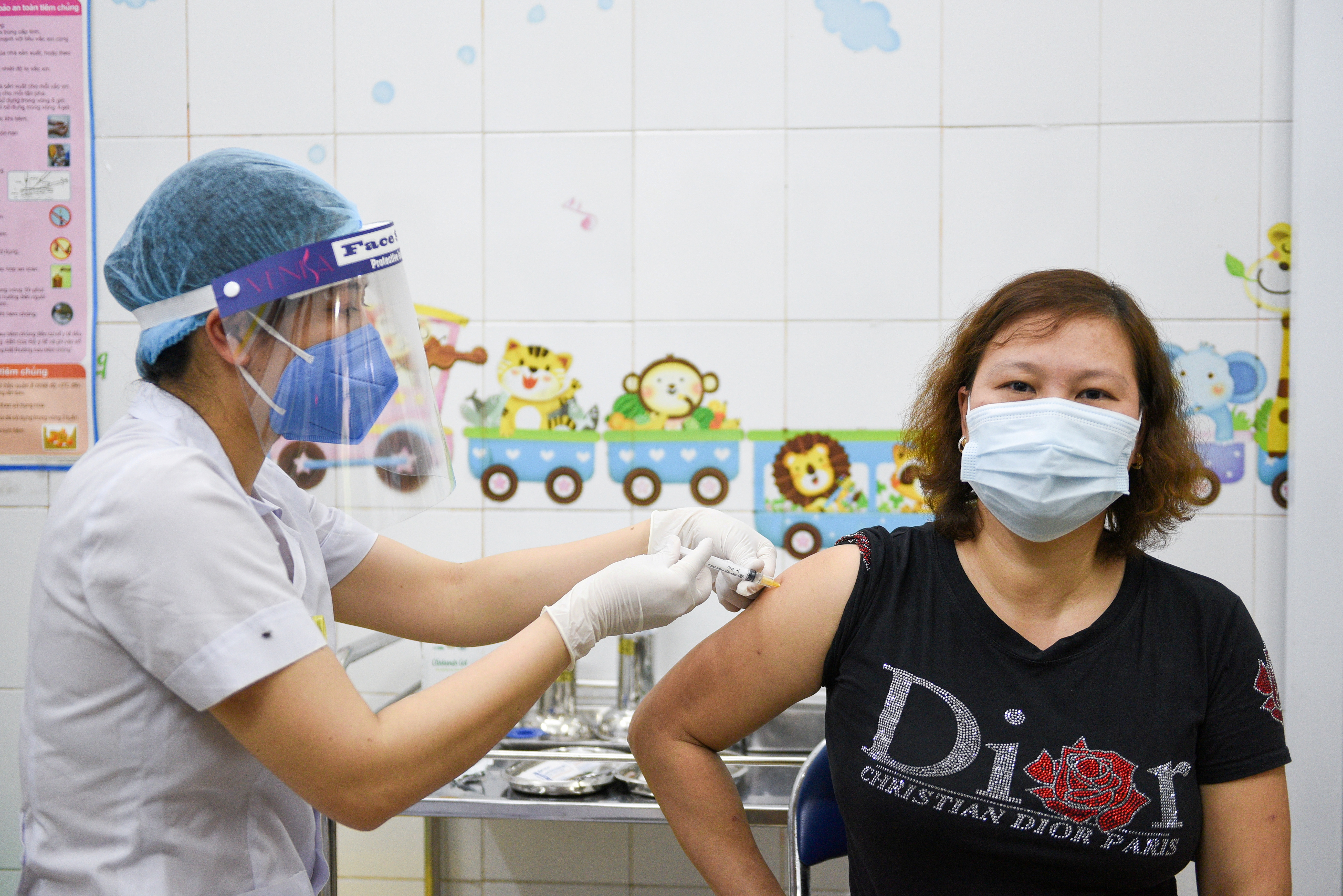 A woman receives a vaccine as Vietnam starts its official rollout of AstraZeneca's coronavirus disease (COVID-19) vaccine for health workers, at Hai Duong Hospital for Tropical Diseases, Hai Duong province, Vietnam, March 8, 2021. REUTERS/Thanh Hue/File Photo