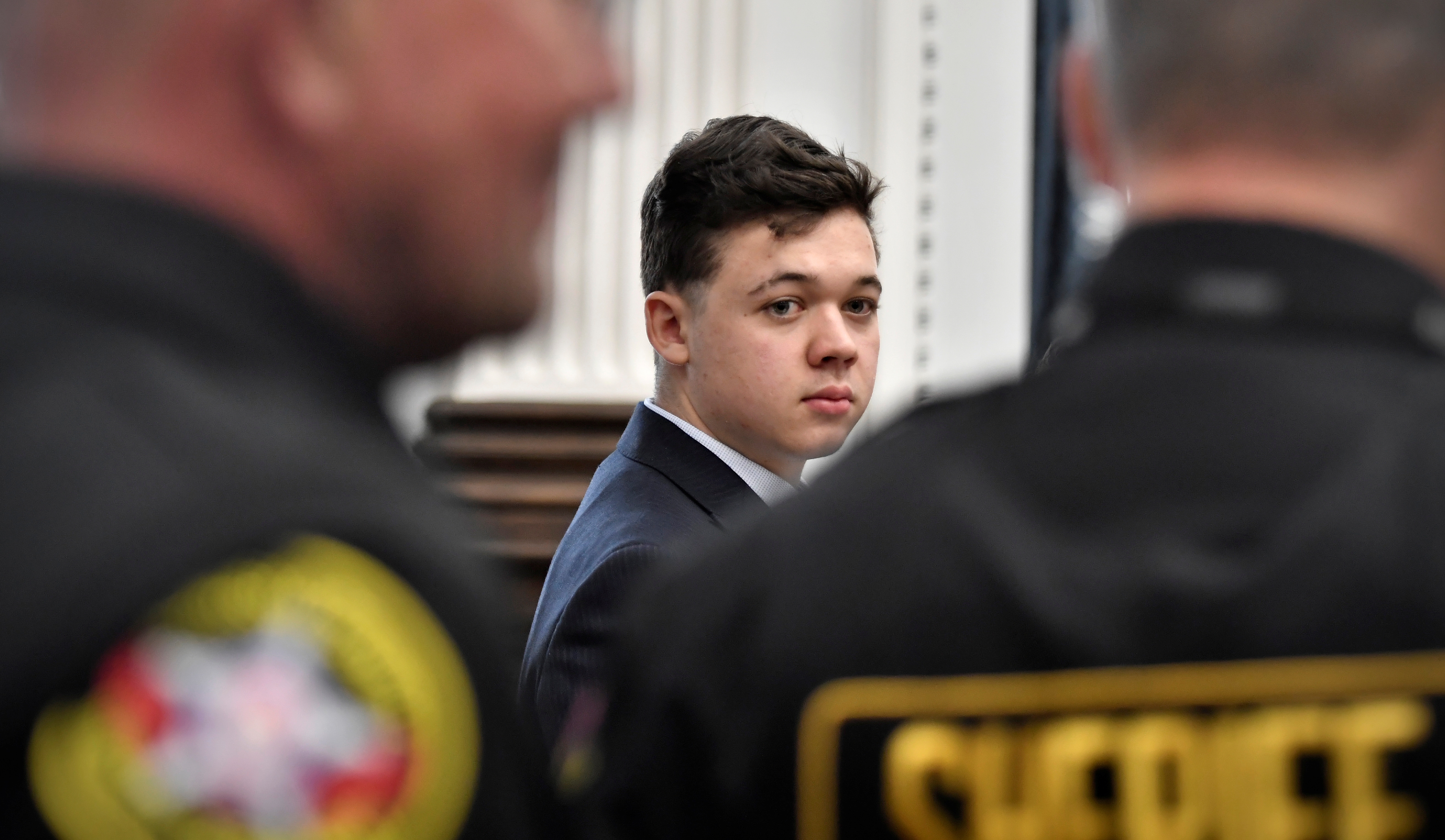 Kyle Rittenhouse looks back as Kenosha County Sheriff's deputies enter the courtroom to escort him out of the room during a break in the trial, at the Kenosha County Courthouse in Kenosha, Wisconsin, U.S., November 5, 2021. Sean Krajacic/Pool via REUTERS/File Photo