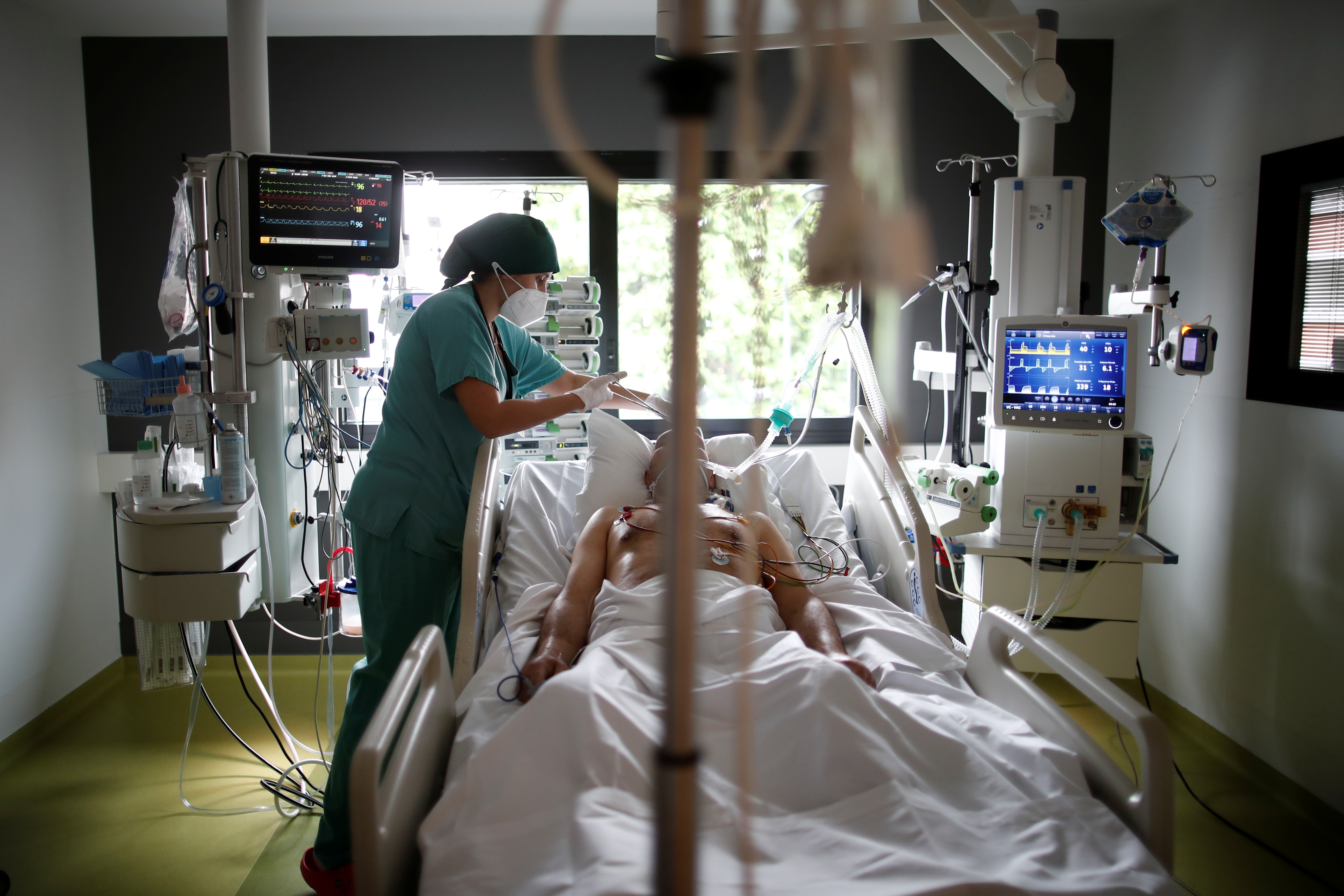 A healthcare worker provides care for a COVID-19 patient in the Intensive Care Unit (ICU) at the Centre Cardiologique du Nord private hospital in Saint-Denis, near Paris, amid the coronavirus disease pandemic in France, May 4, 2021. REUTERS/Benoit Tessier