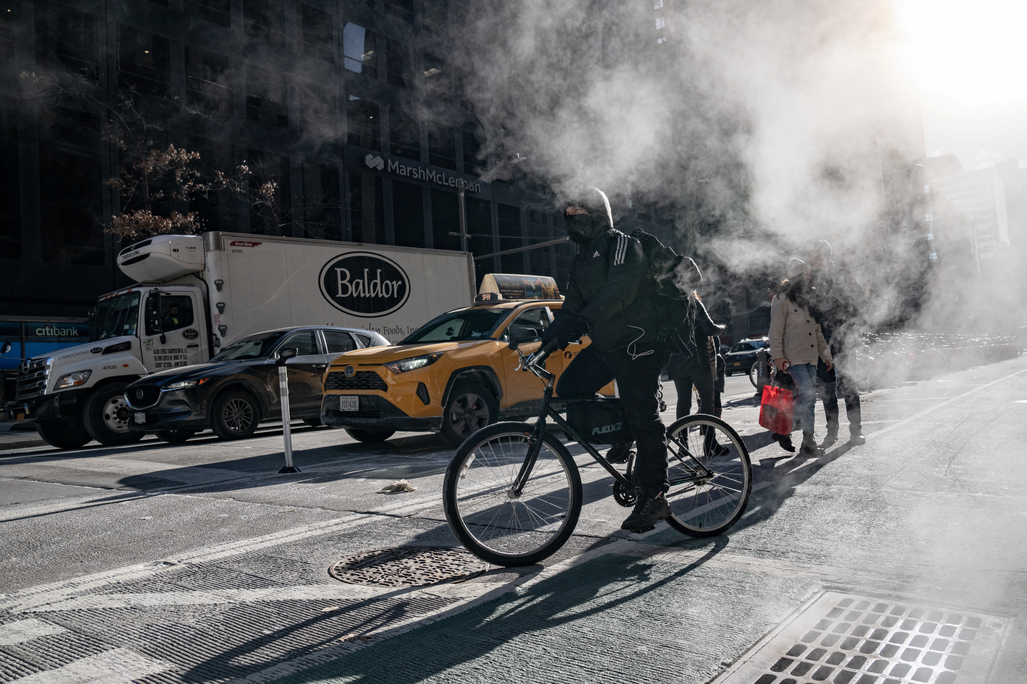A biker wearing a mask rides a bicycle on Christmas Eve in Manhattan