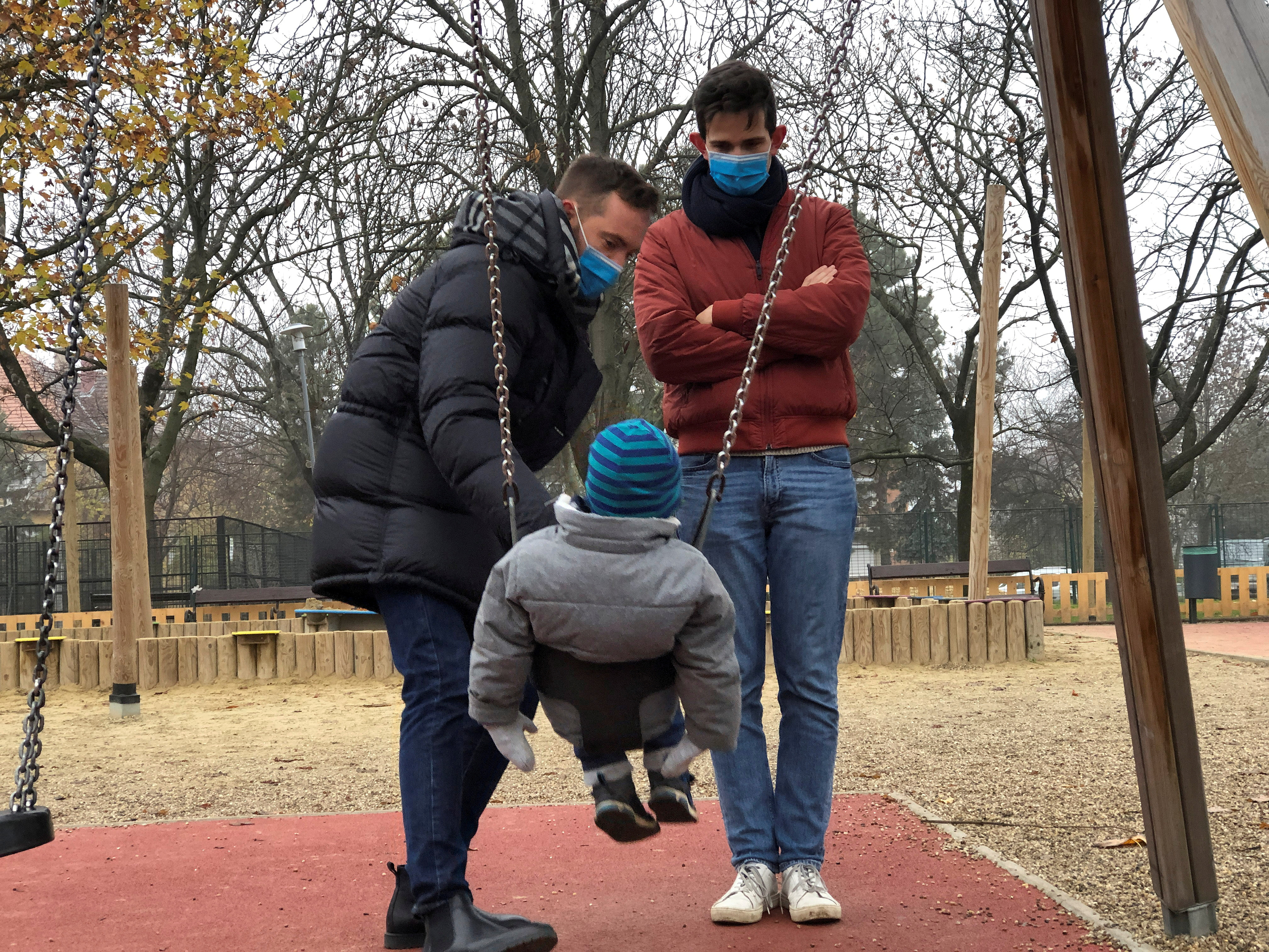 Same sex couple Adam Hanol and Marton Pal play with their four year old adopted son Andras at a playground in Budapest