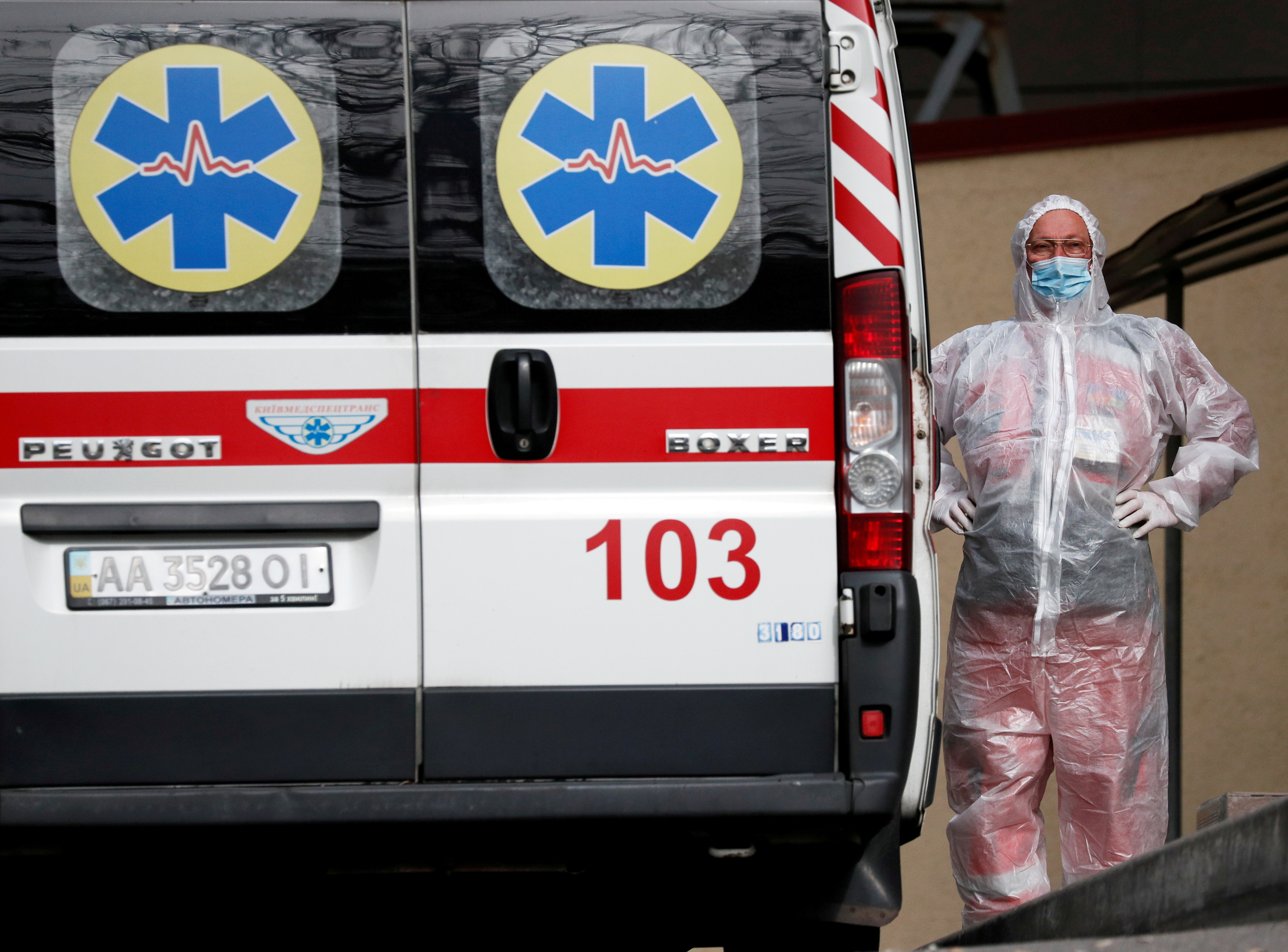 A health worker stands near an ambulance carring a COVID-19 patient, as they wait in the queue at a hospital for people infected with the coronavirus disease in Kyiv, Ukraine October 18, 2021.  REUTERS/Gleb Garanich