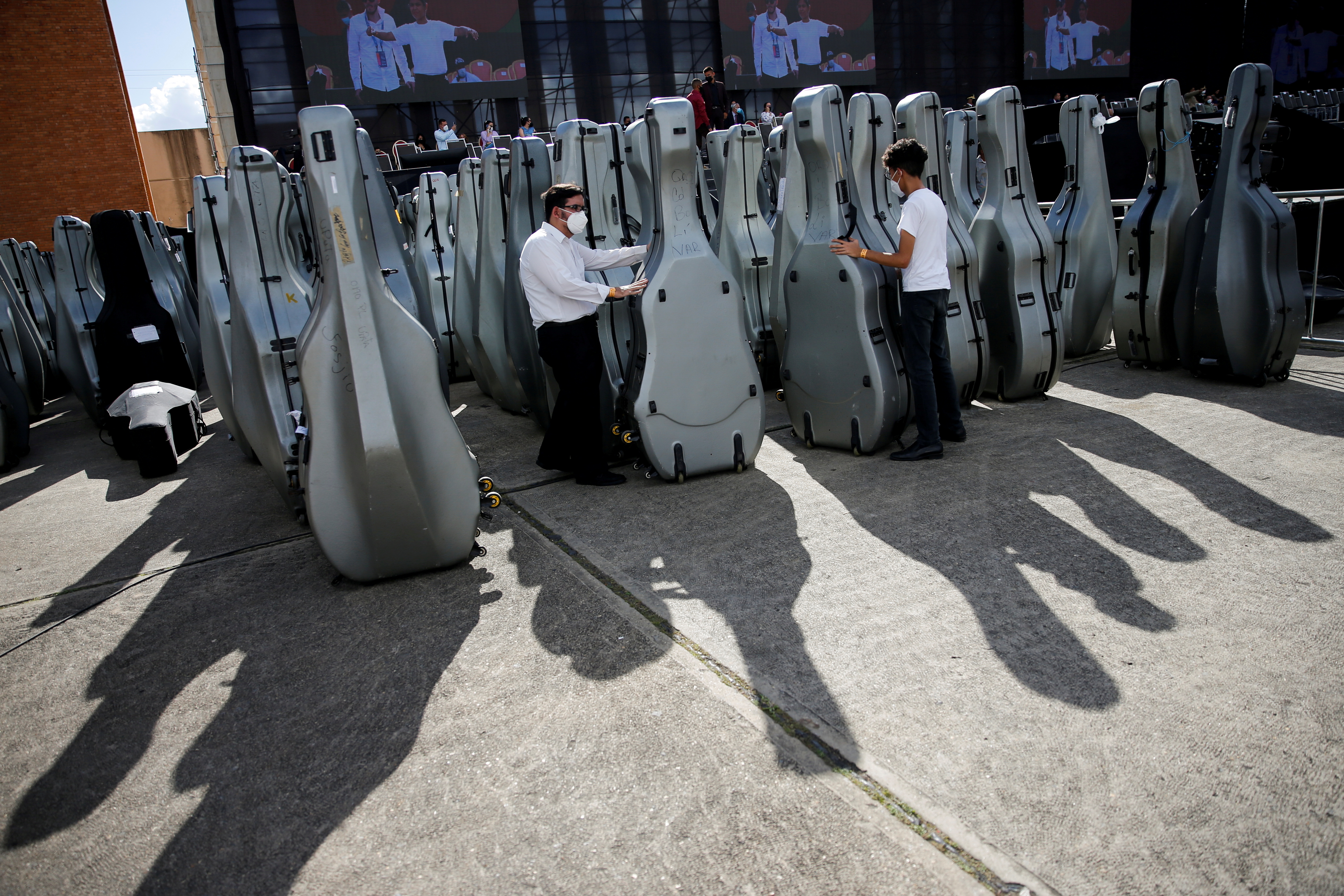 Members of Venezuela's National System of Youth Orchestras and Choirs handle instruments cases before a concert as they try to break the Guinness World Record for the largest orchestra in the world, in Caracas, Venezuela November 13, 2021. REUTERS/Leonardo Fernandez Viloria 