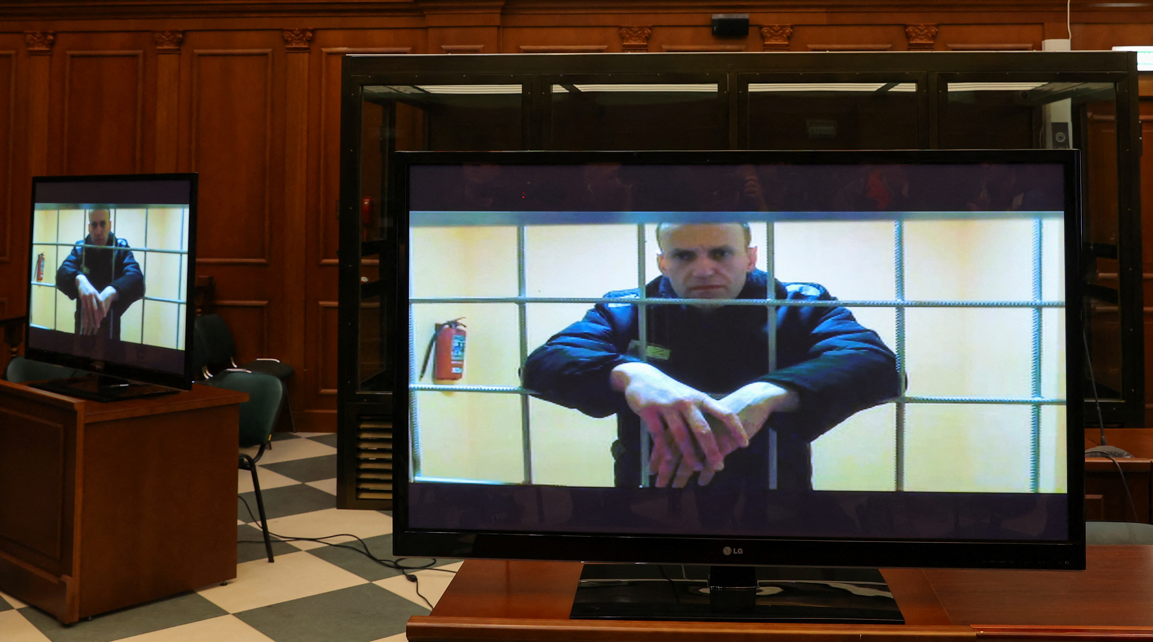 Jailed Russian opposition leader Alexei Navalny is seen on screens during a court hearing in Moscow