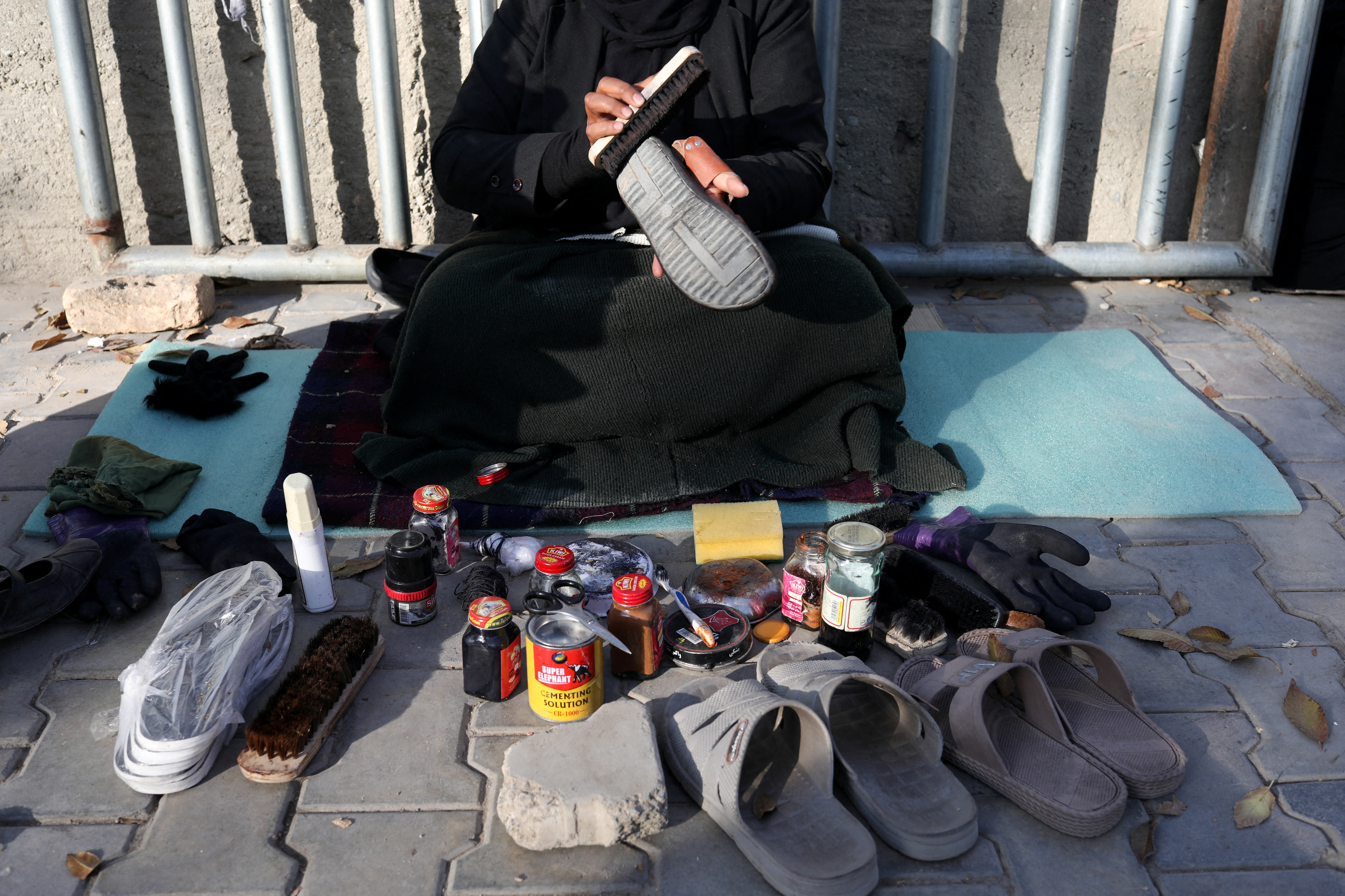 Hadia Ahmadi, 43, waxes shoes, in Kabul