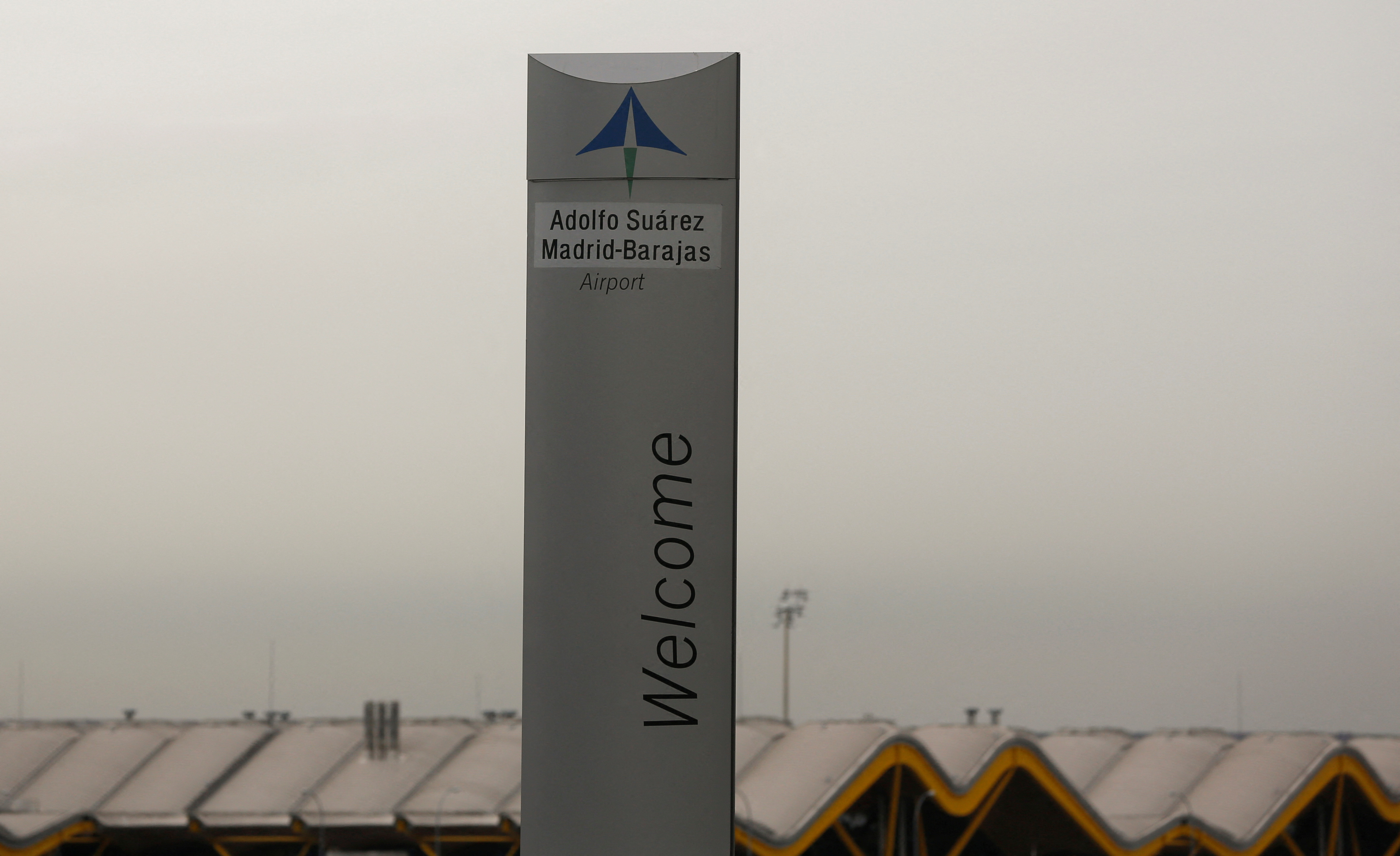 The logo of Spanish airports operator Aena is seen on the top of a welcoming sign outside Adolfo Suarez Barajas airport in Madrid