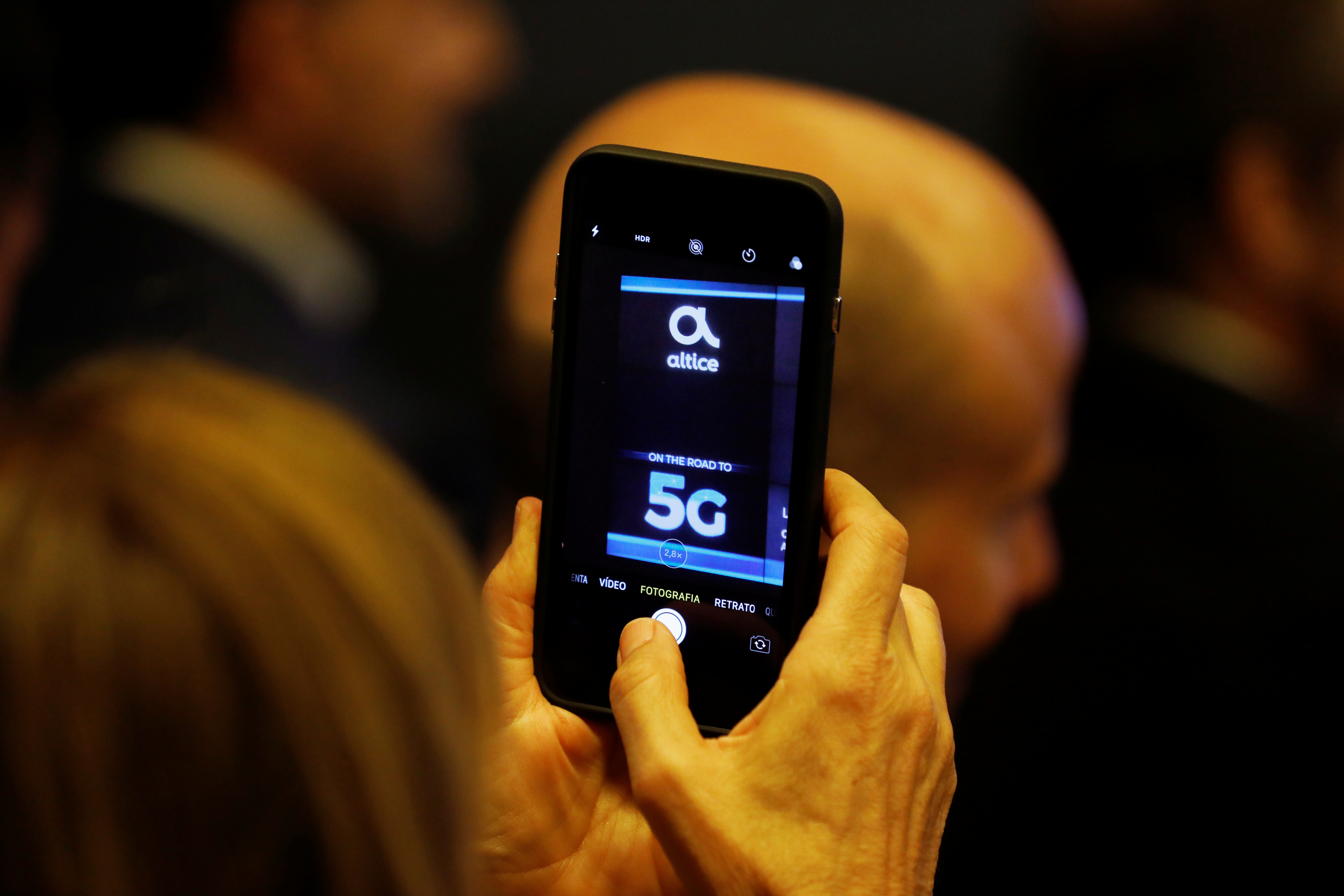 A woman takes pictures during the first demonstration of the technology 5G in Lisbon