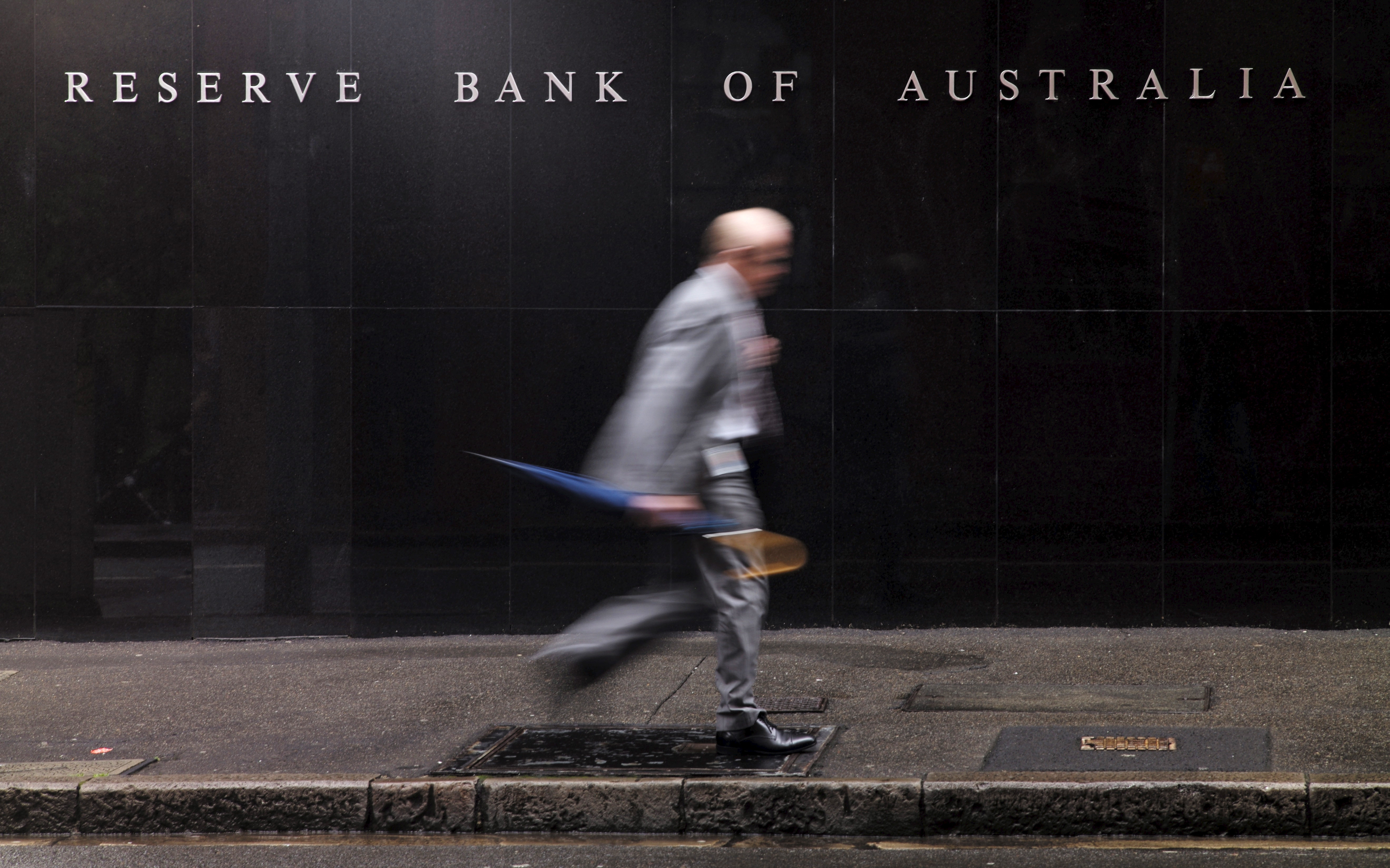 Man walks past the headquarters of Australia's Reserve Bank in Sydney