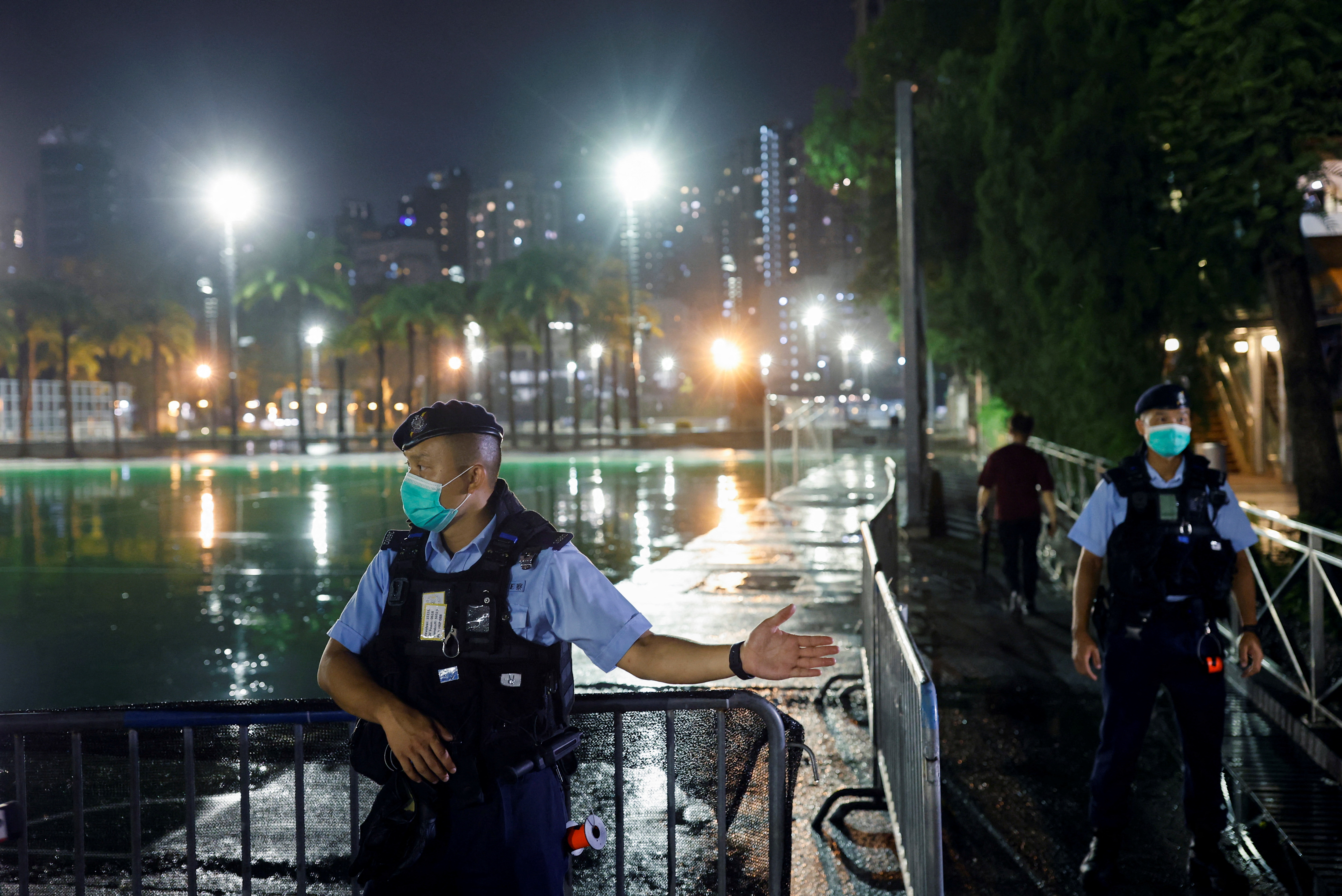 A police officer asks people to leave after announcing a closure of a part of Victoria Park, ahead of Tiananmen anniversary, in Hong Kong