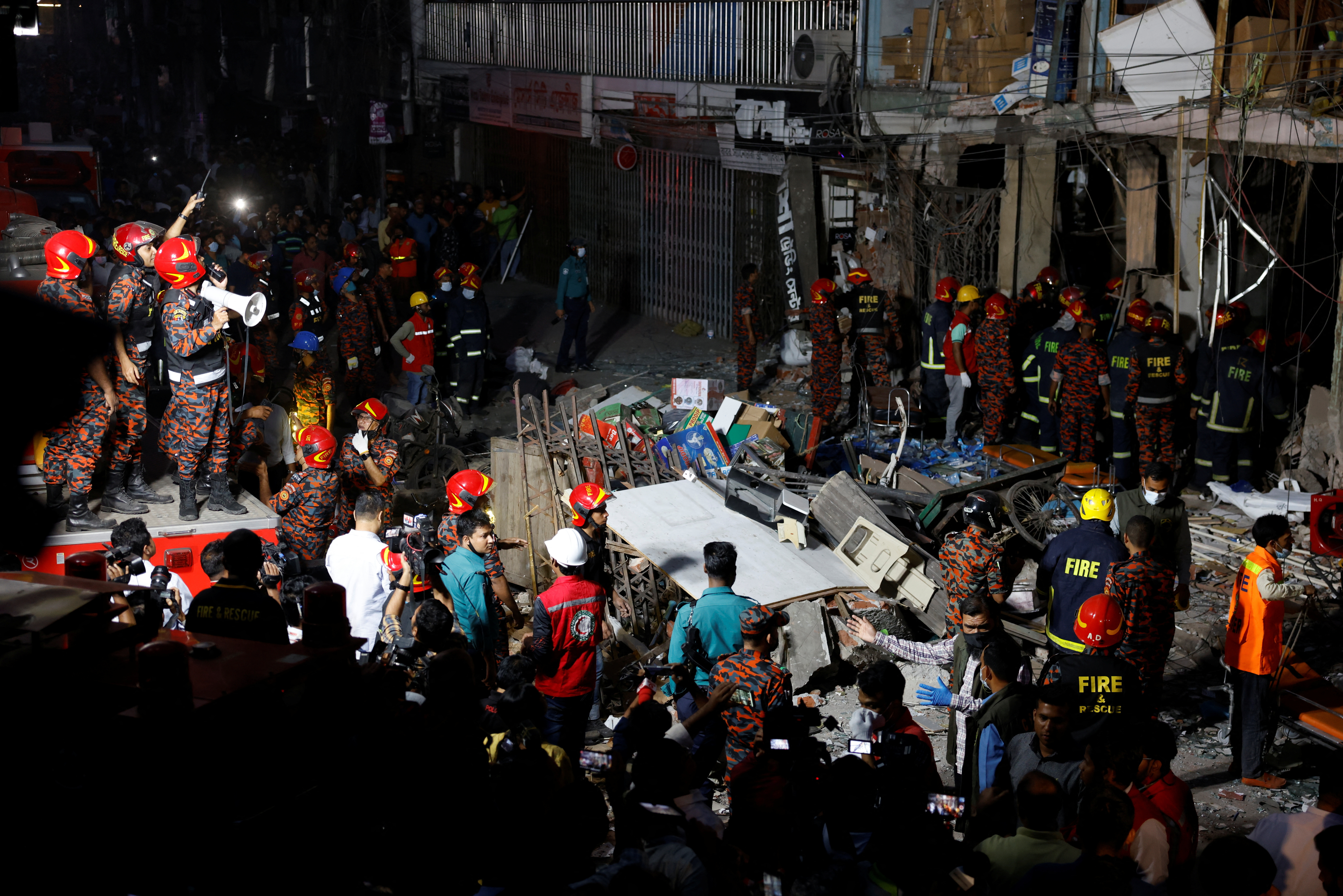 Bomberos y rescatistas se ven en la escena de una explosión en un edificio de varios pisos en Dhaka.